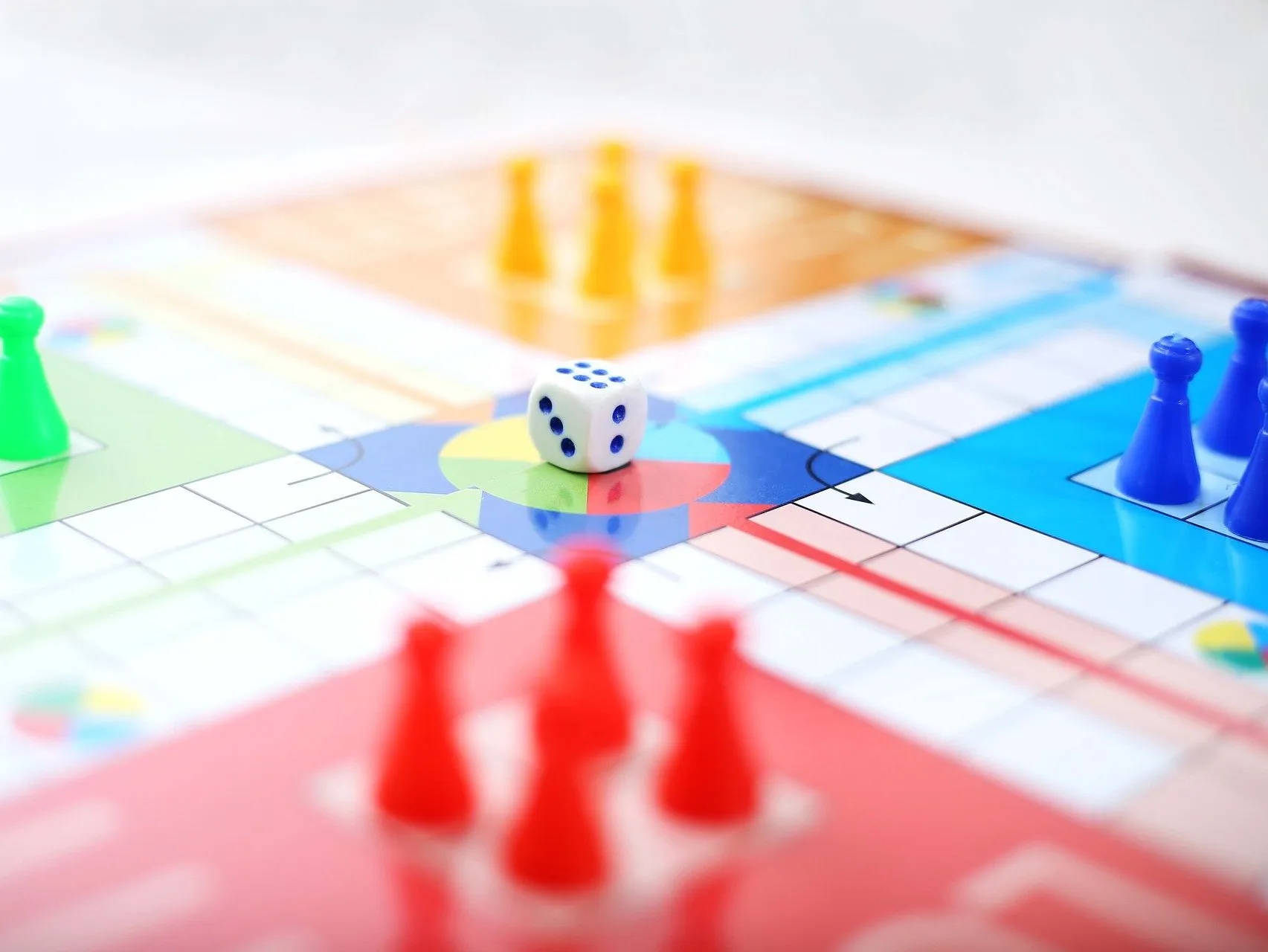 色彩繽紛的棋盤遊戲，聚焦於棋子和骰子。