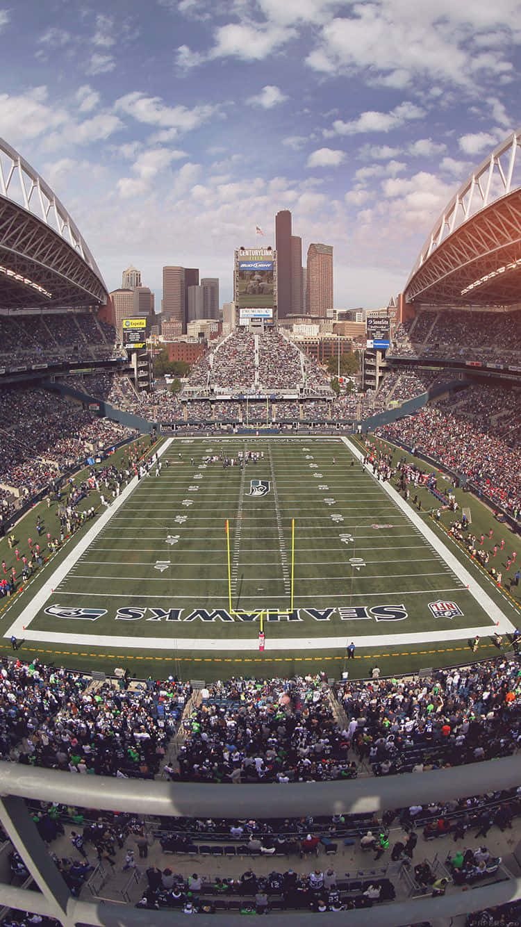 Football Stadium 桌布 壁紙 — Lumen Field 的空中景觀，在部分多雲的天空下，西雅圖海鷹隊比賽中擠滿了歡呼的球迷。