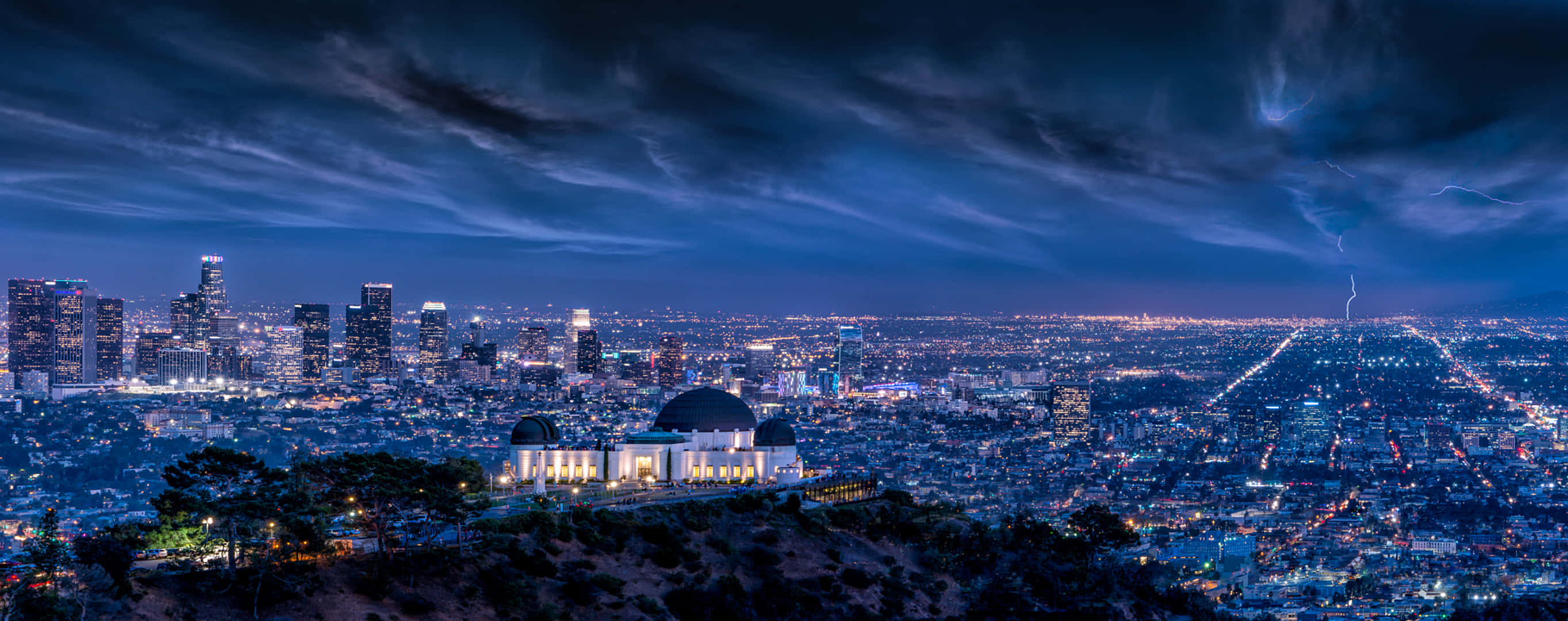 La 桌布 壁紙 — 洛杉磯天際線的戲劇性夜景，格里菲斯天文台在暴風雨的天空下被閃電照亮。
