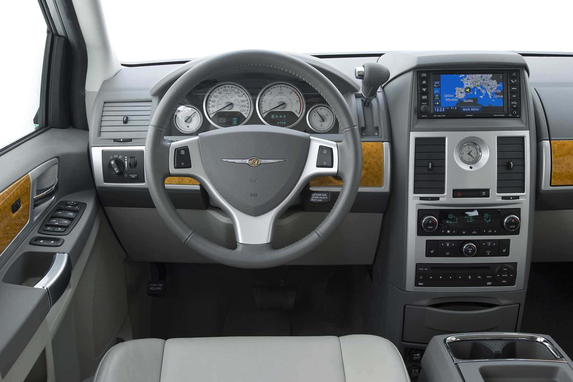 Chrysler Voyager 桌布 壁紙 — 豪華車內飾，灰色皮革座椅，木質飾邊和數碼導航屏幕。