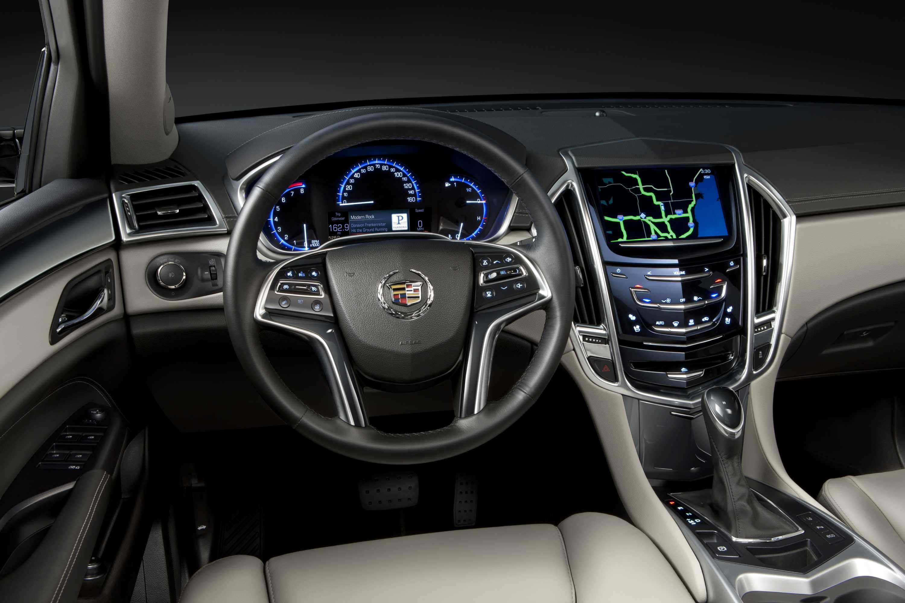 Cadillac Srx 桌布 壁紙 — 豪華車內飾，配有藍色發光儀表板和米色皮革座椅，在工作室燈光下。
