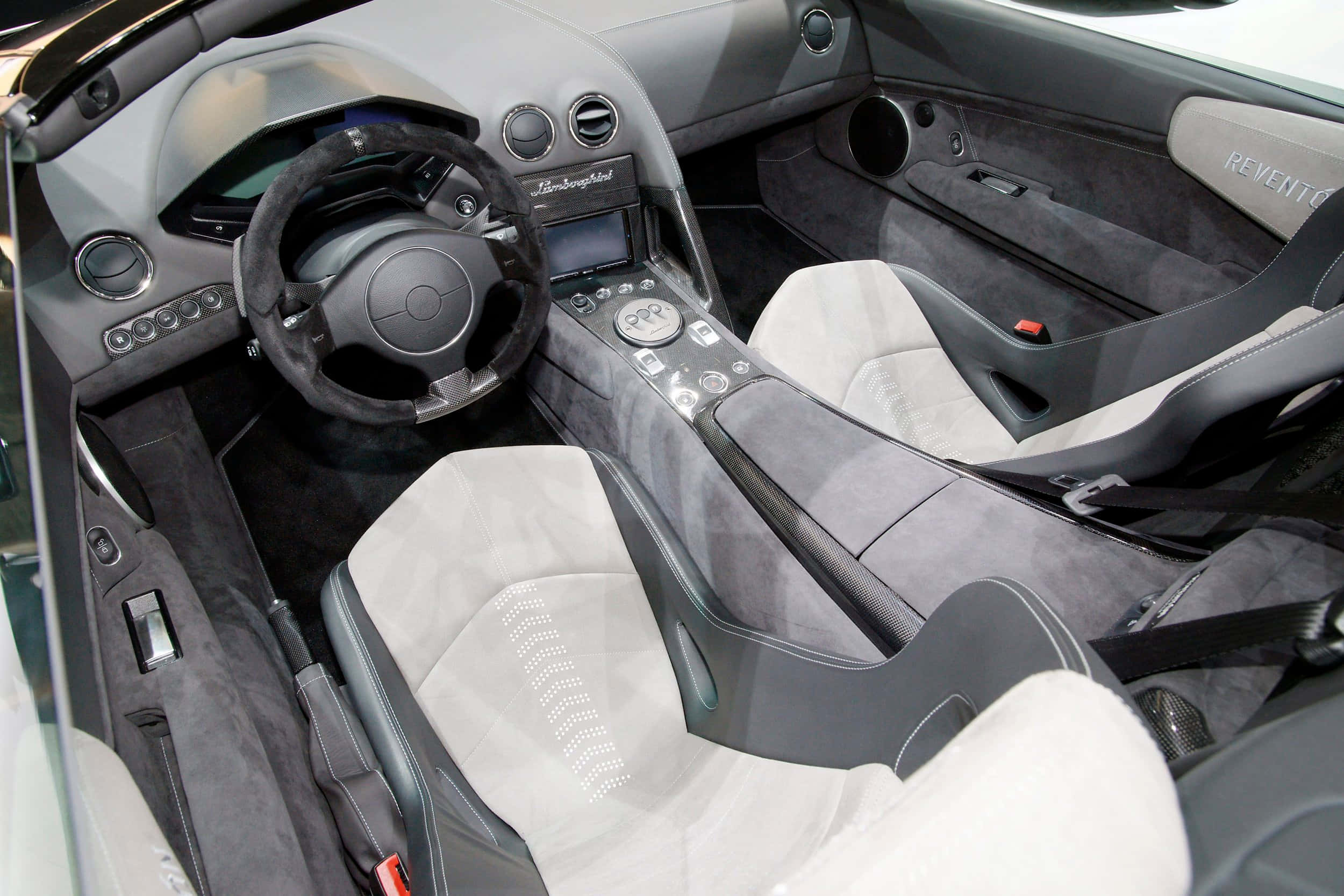 Lamborghini Reventón 桌布 壁紙 — 豪華跑車內飾，配備灰色絨面座椅和黑色碳纖維飾邊，展現高端工藝。