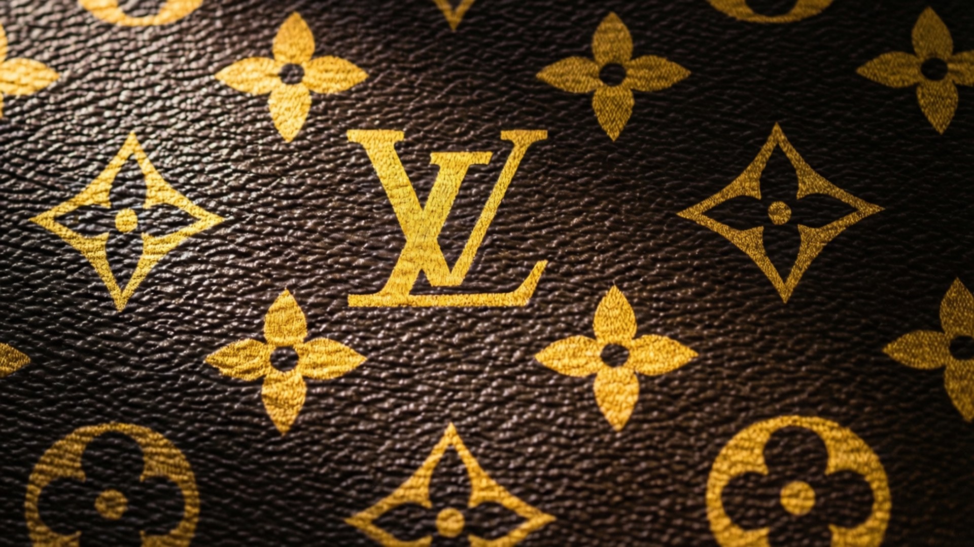 棕色皮革帶有金色 Louis Vuitton 字母組合圖案和紋理縫線。