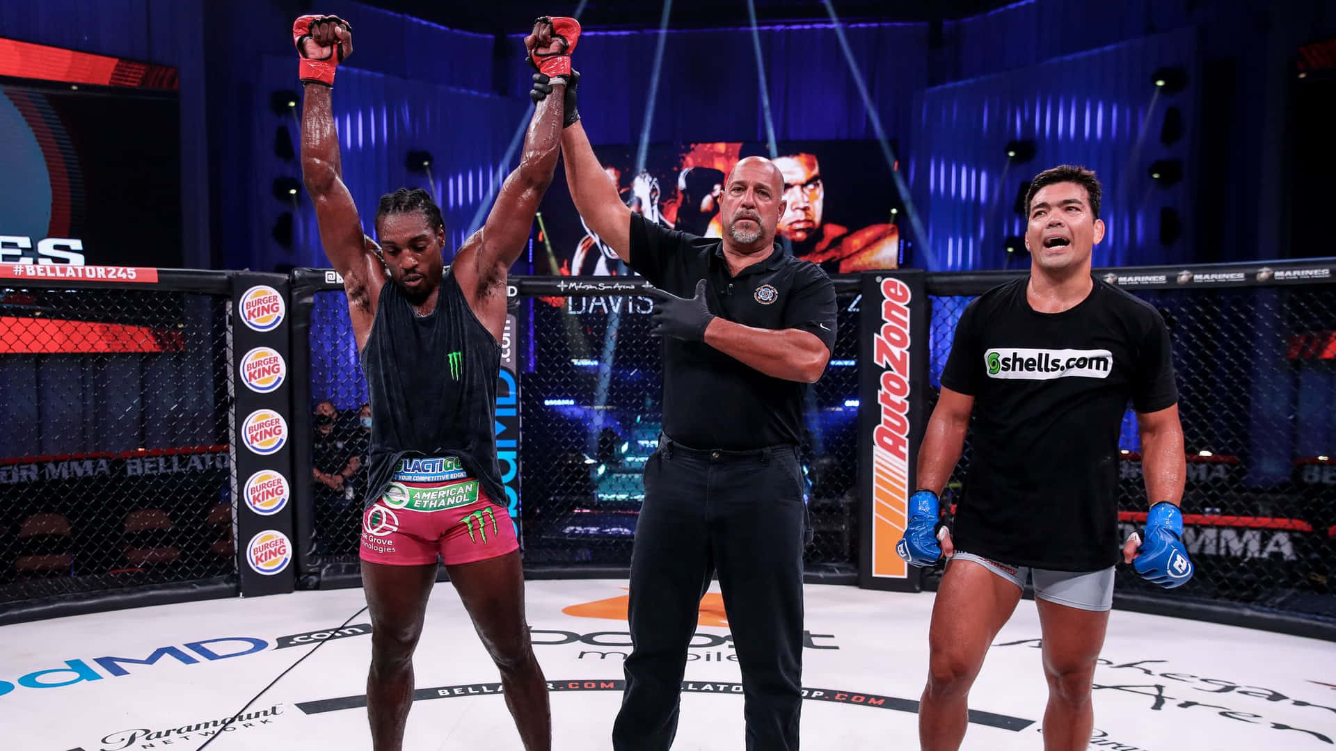 MMA拳手在八角籠中慶祝勝利，裁判舉起他的手。