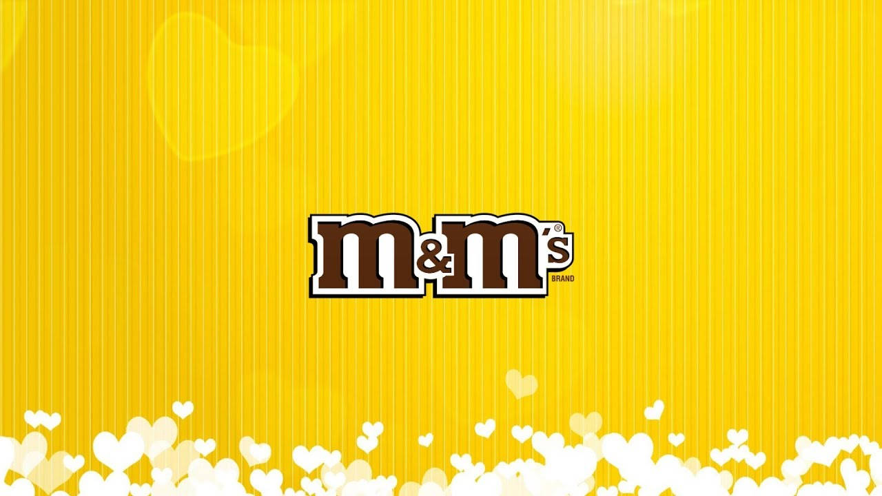 M&M's 標誌在黃色條紋背景上，帶白色心形散景 — 黃色美學 壁紙