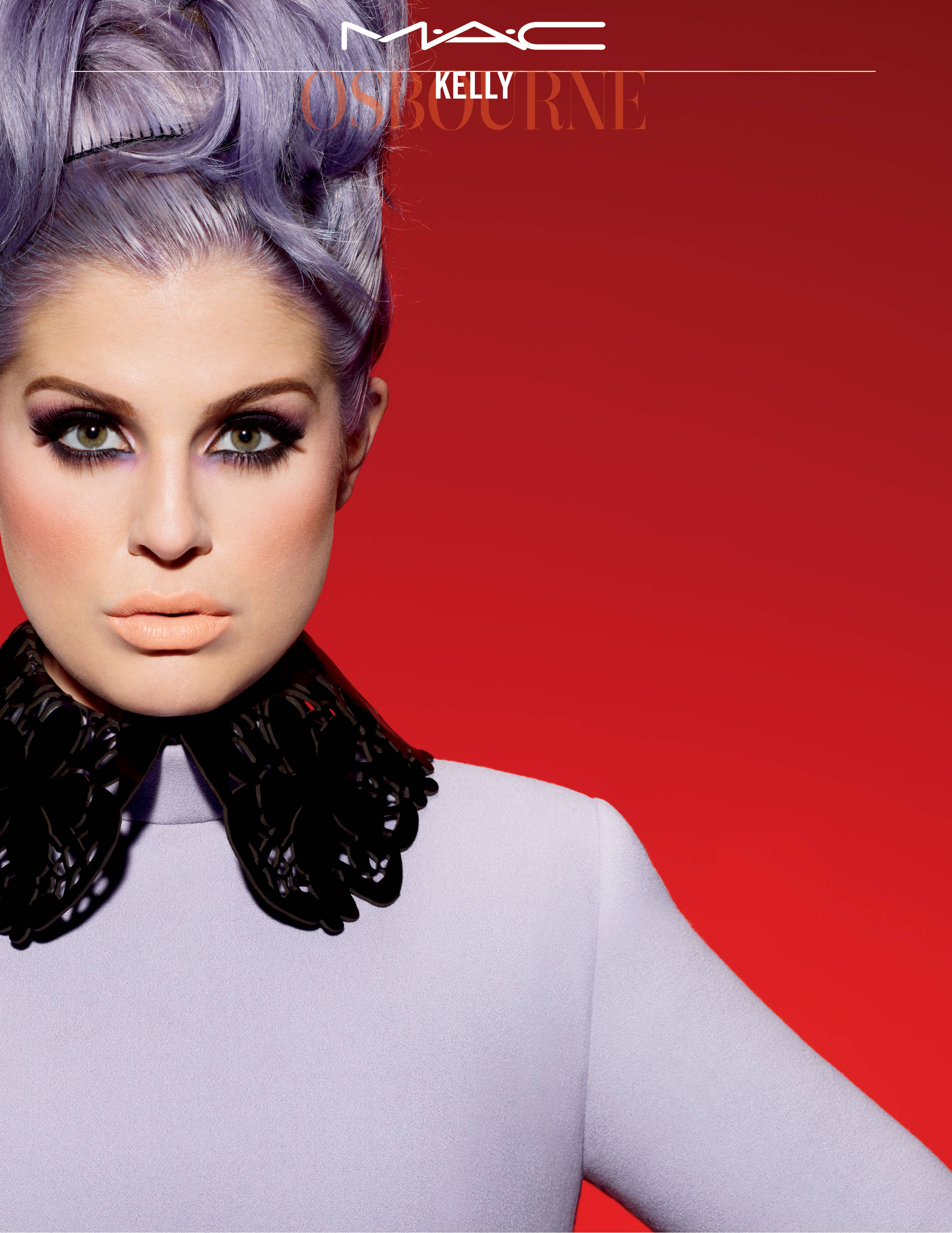 Mac Cosmetics 與 Kelly Osbourne 合作 壁紙 — 一位擁有薰衣草色頭髮和大膽妝容的女性，穿著黑色蕾絲領，在鮮紅色的背景下強烈凝視。
