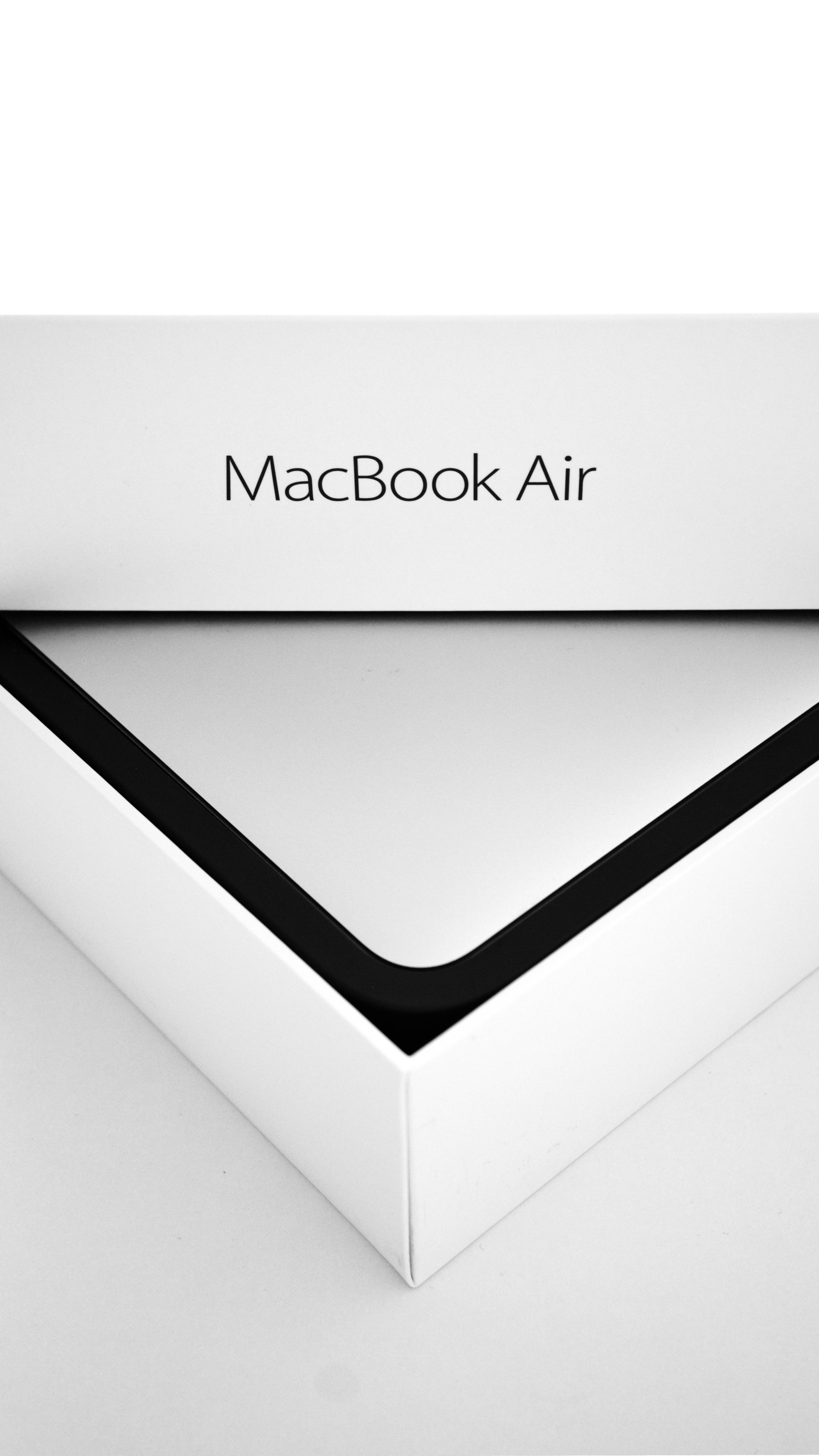 MacBook Air 2020包裝盒 壁紙 — 白色MacBook Air包裝盒的特寫，黑色邊框和極簡字體設計，背景為純白色。