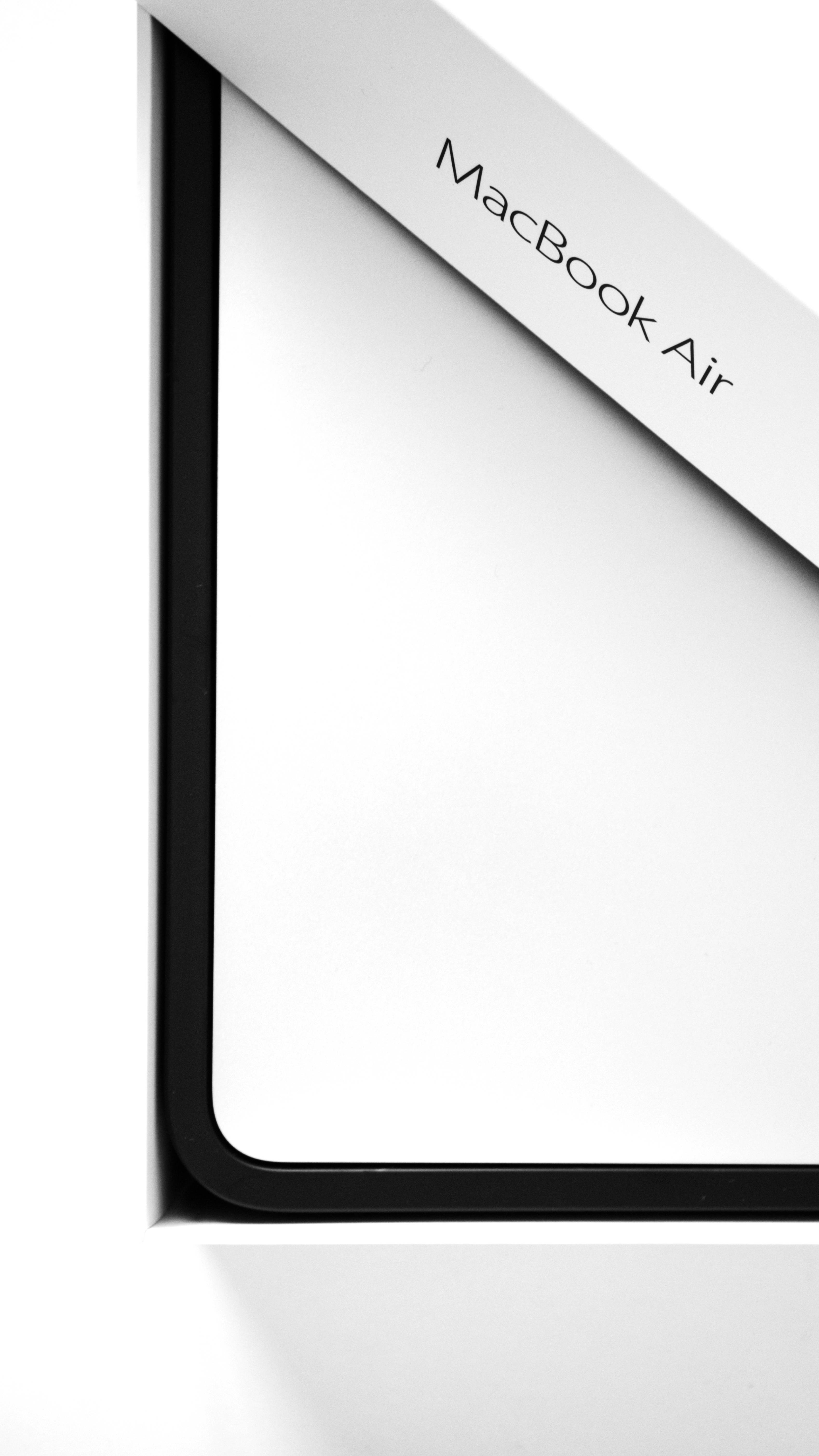 MacBook Air 2020包裝盒斜角視圖 壁紙 — MacBook Air 角落的極簡特寫，純白背景上呈現乾淨的白色和黑色線條。
