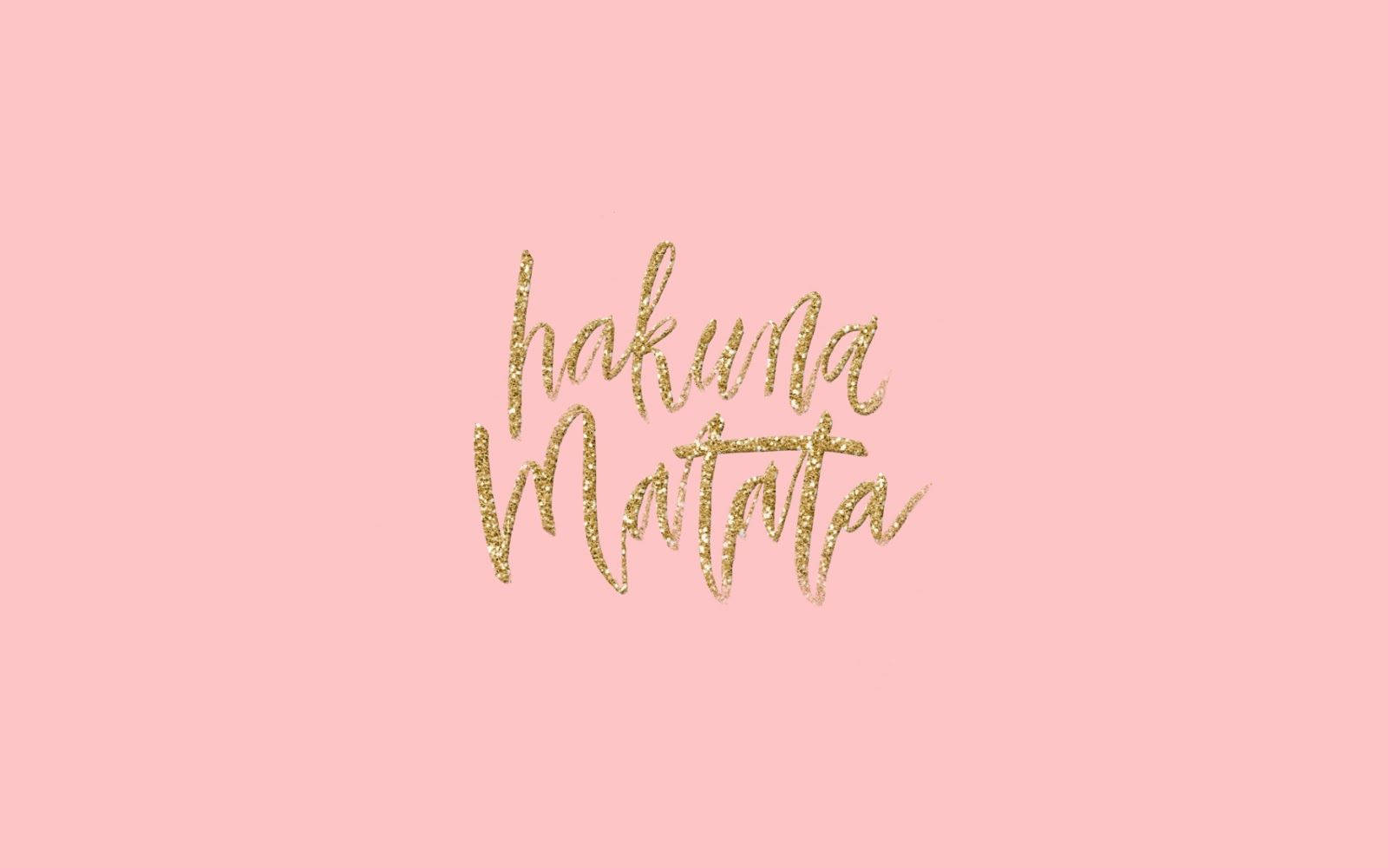 可愛MacBook Pro螢幕保護程式 壁紙 — 金色閃亮的 'hakuna matata' 字體漂浮在柔和的粉紅色背景上，沒有其他元素。