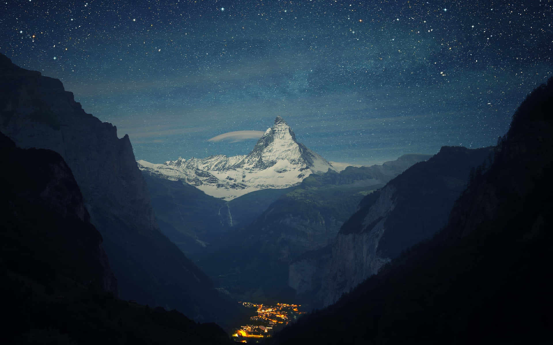 星空下積雪的山頂與山谷中發光的村莊