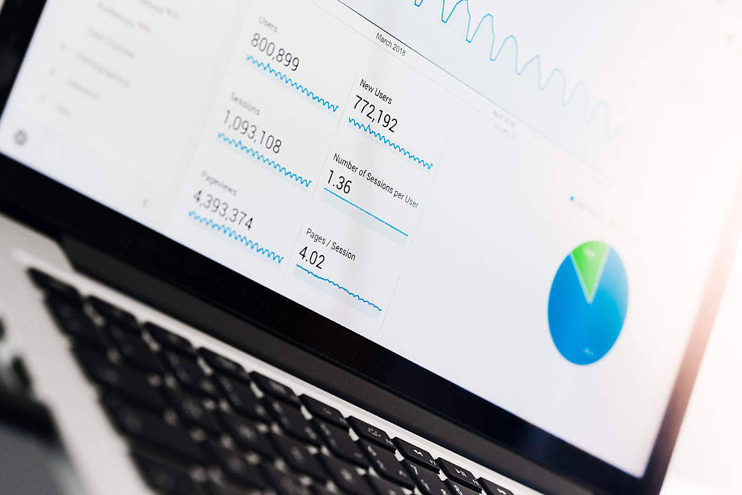 MacBook顯示Google Analytics網站 壁紙 — 近距離拍攝筆記型電腦屏幕，顯示帶有圖表和圖形的網站分析，背景為模糊鍵盤。