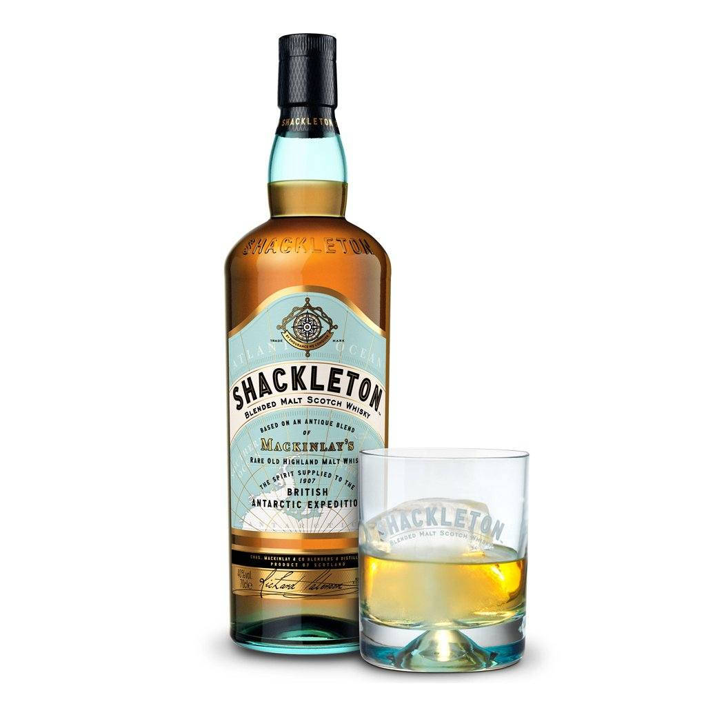 Shackleton 威士忌酒瓶和帶冰塊的玻璃杯在白色背景上。