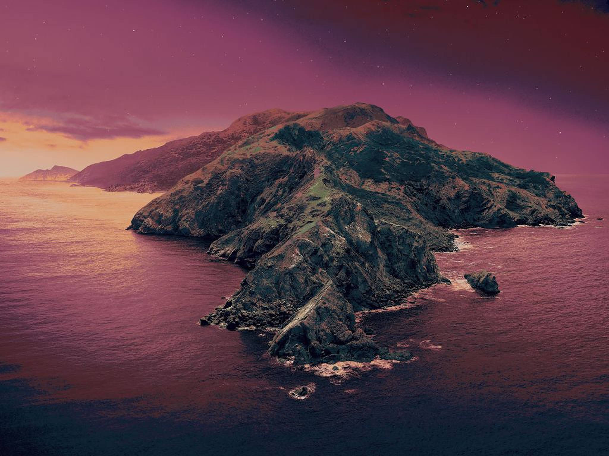 macOS Catalina 粉紅天空 壁紙 — 一座崎嶇的島嶼從深紫色的水域中升起，在閃爍著洋紅色和橙色色調的星空暮色天空下。