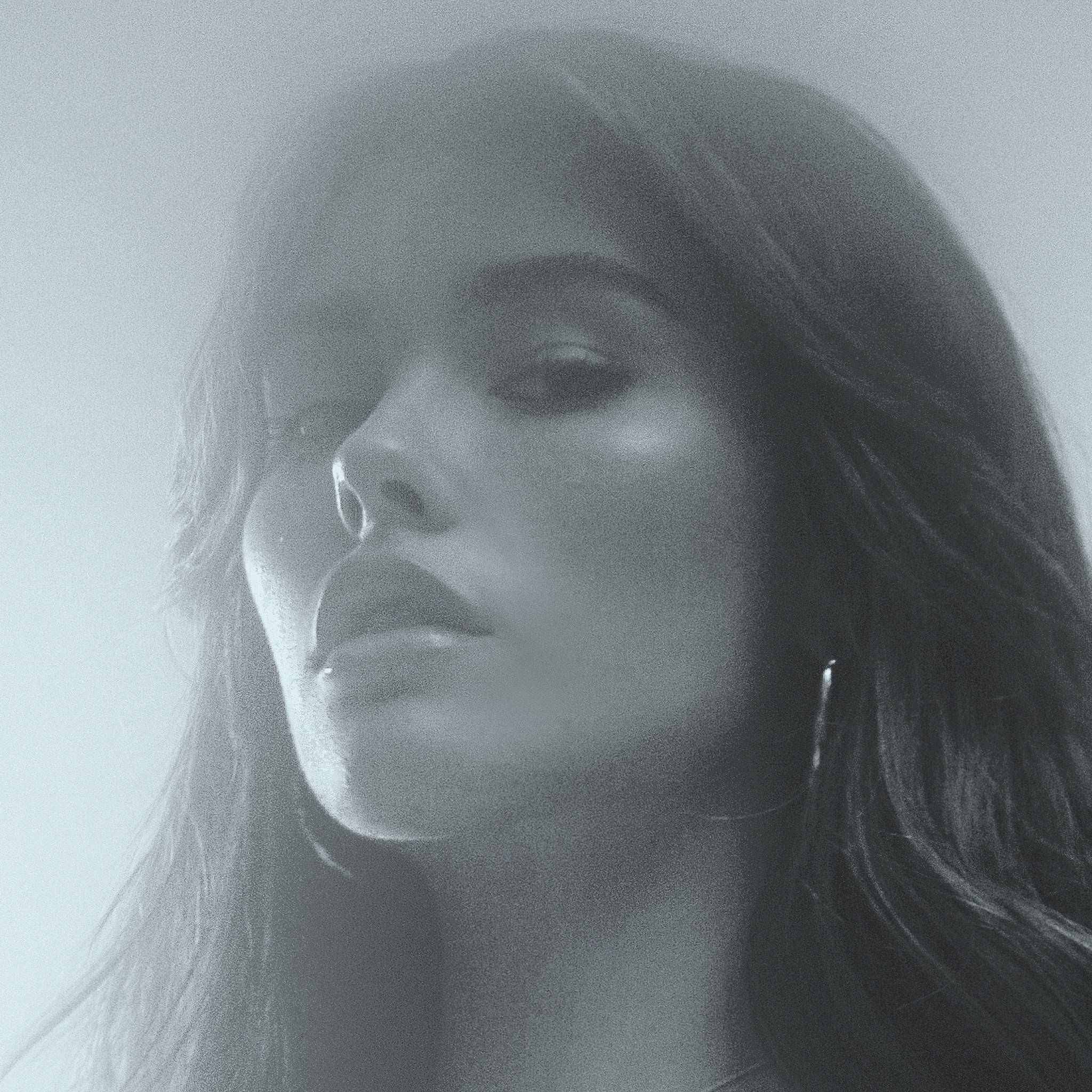 Madison Beer 黑白近照 壁紙 — 一位長黑髮女性在柔和漫射光中向上凝視的黑白肖像。