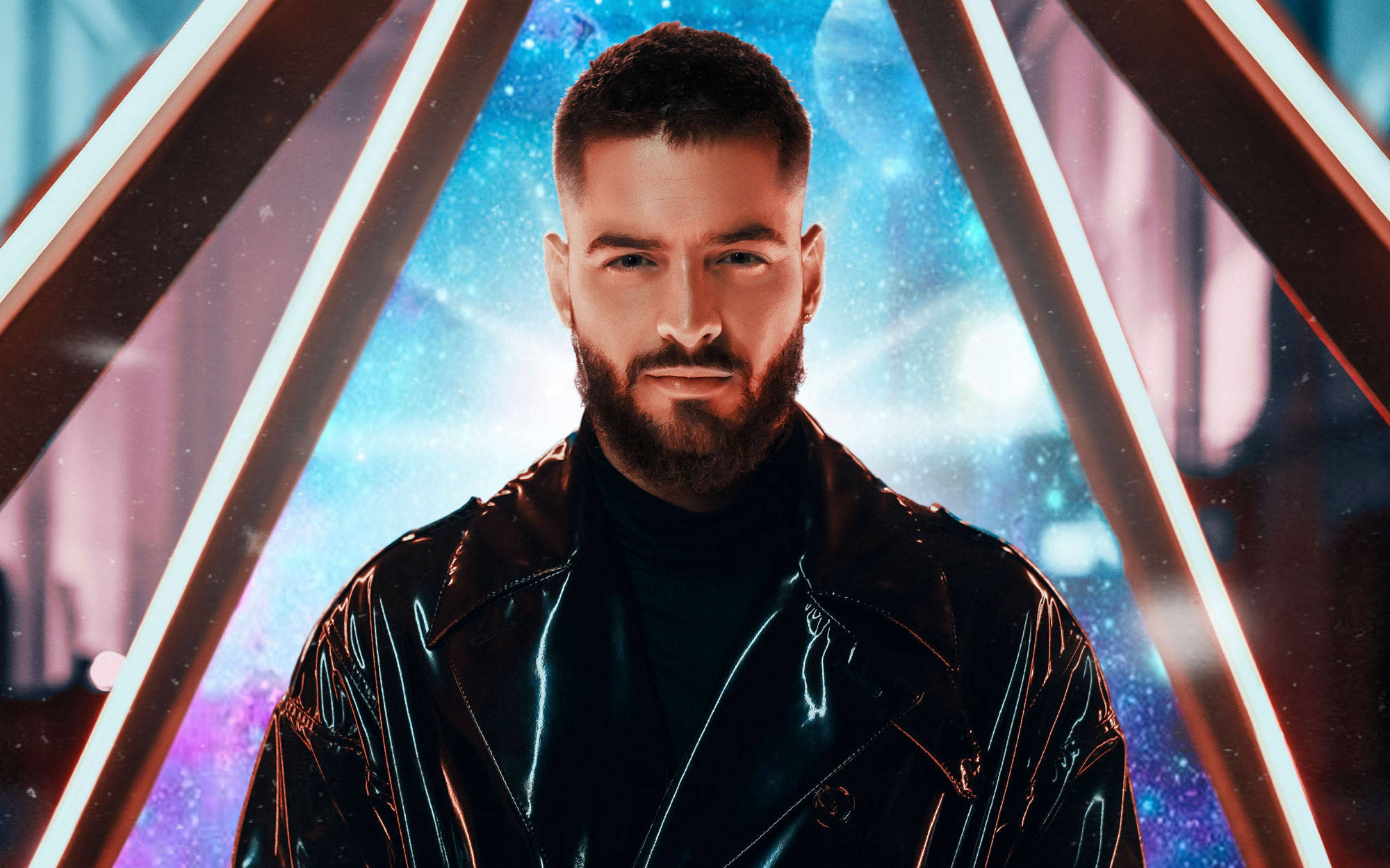 Maluma《11:11》專輯封面 壁紙 — 一個留鬍鬚的男人穿著閃亮的黑色外套，自信地站在發光霓虹三角形框內，背景是宇宙星空。
