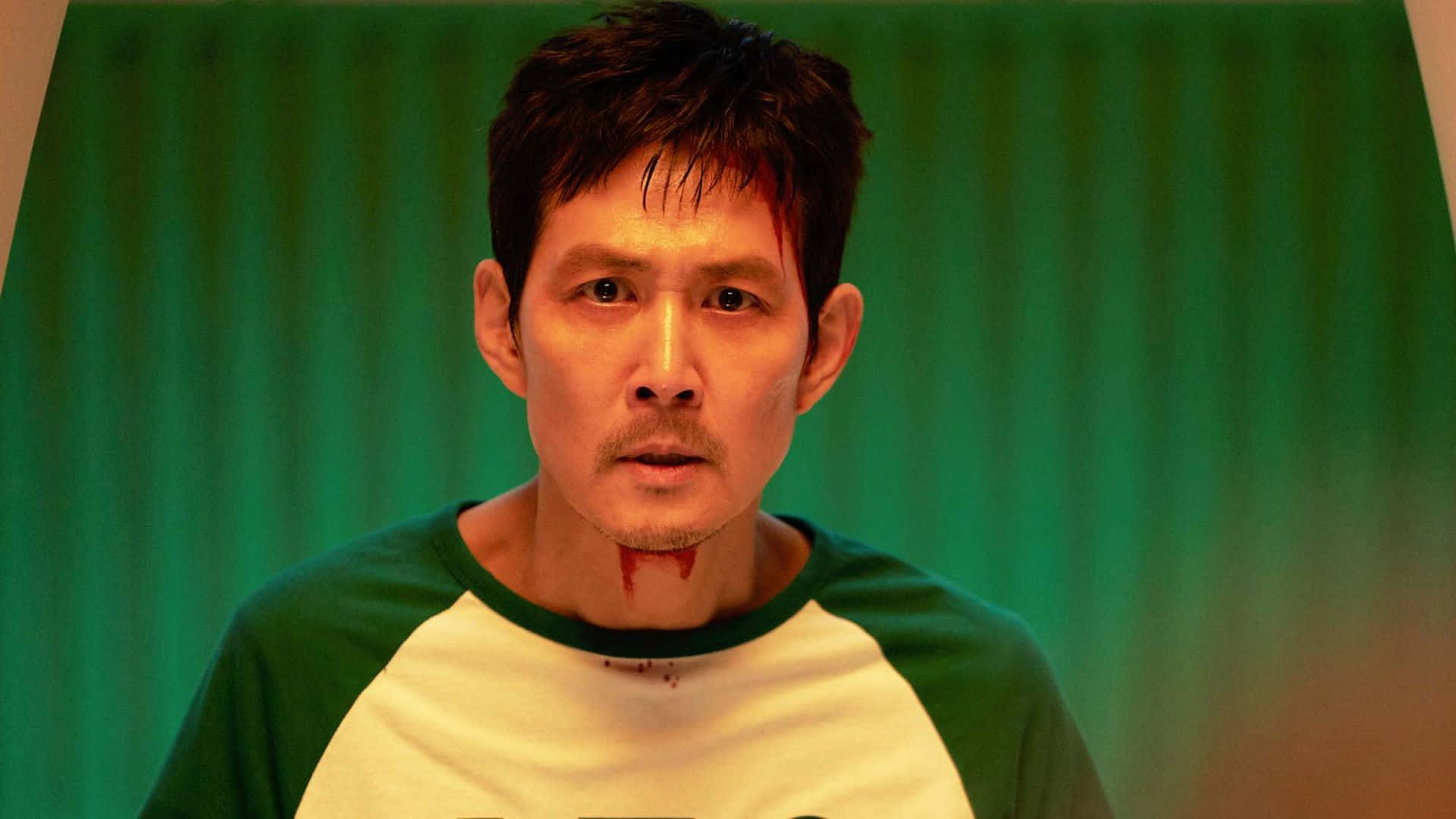  壁紙 — 一名頸上有血的男人在綠色窗簾背景下強烈凝視。