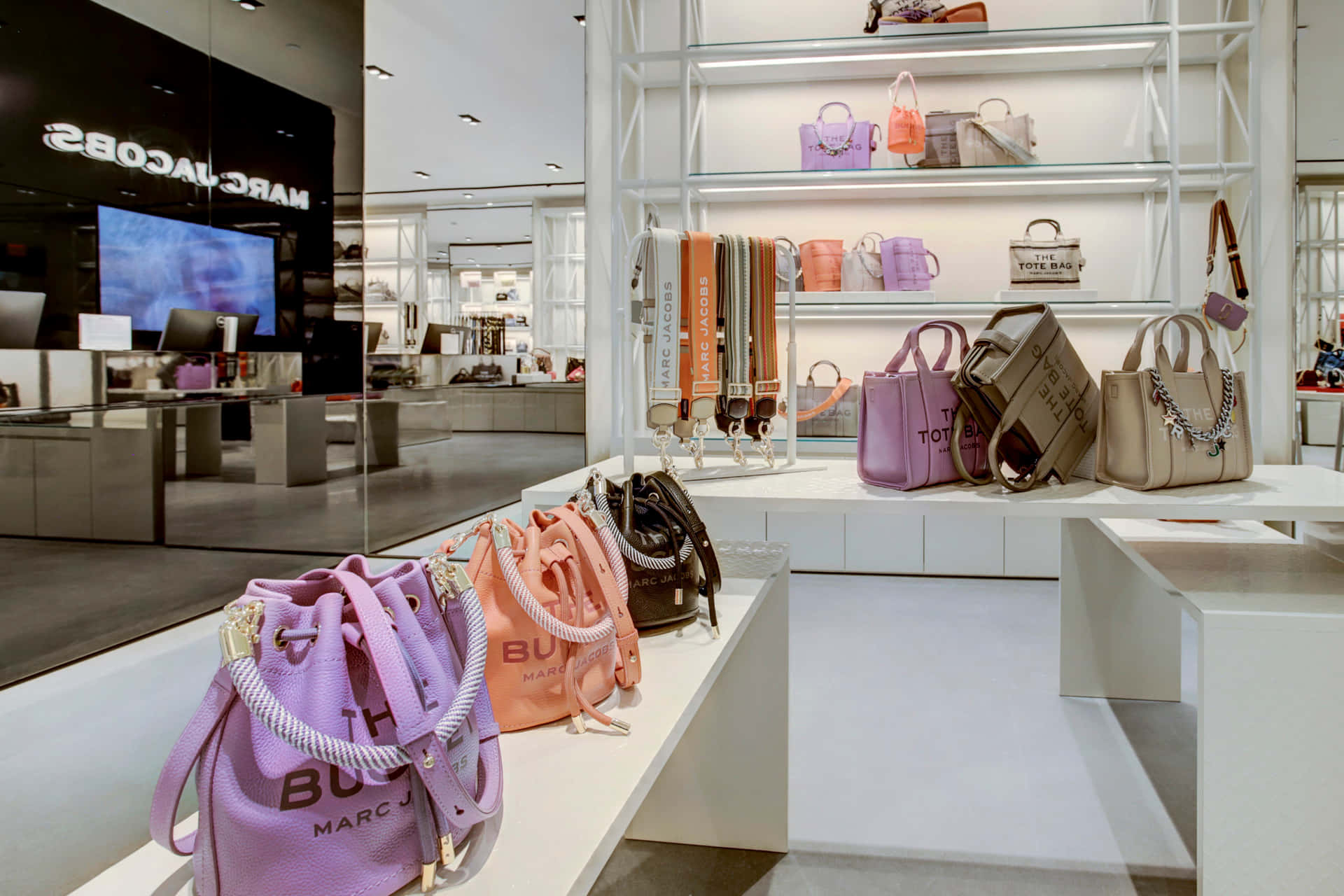 粉紅色、橙色和米色的Marc Jacobs手袋在現代零售店中展示。
