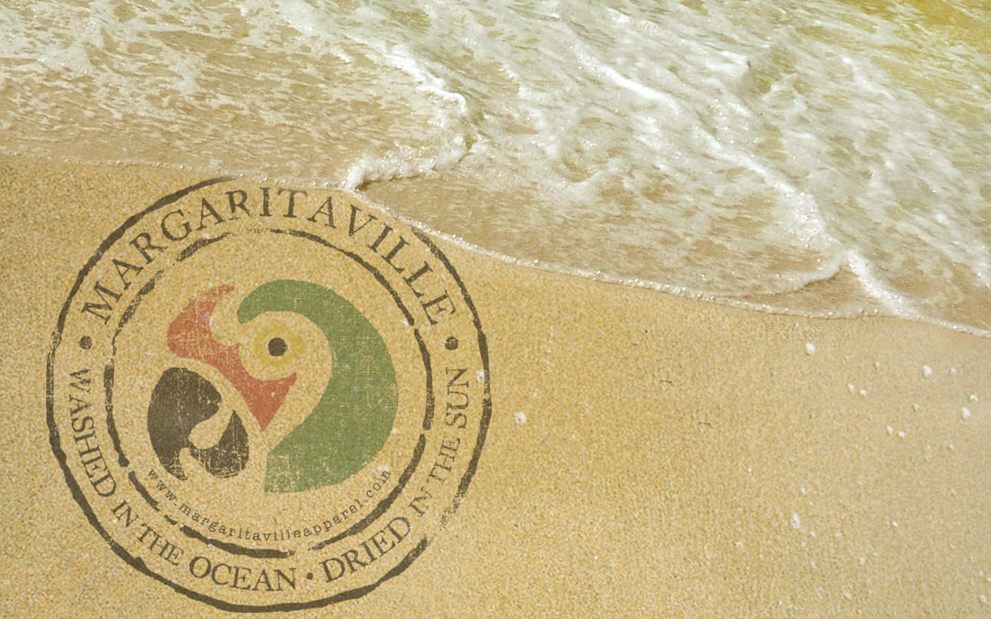 沙灘上繪製的Margaritaville標誌，海浪沖刷其上。