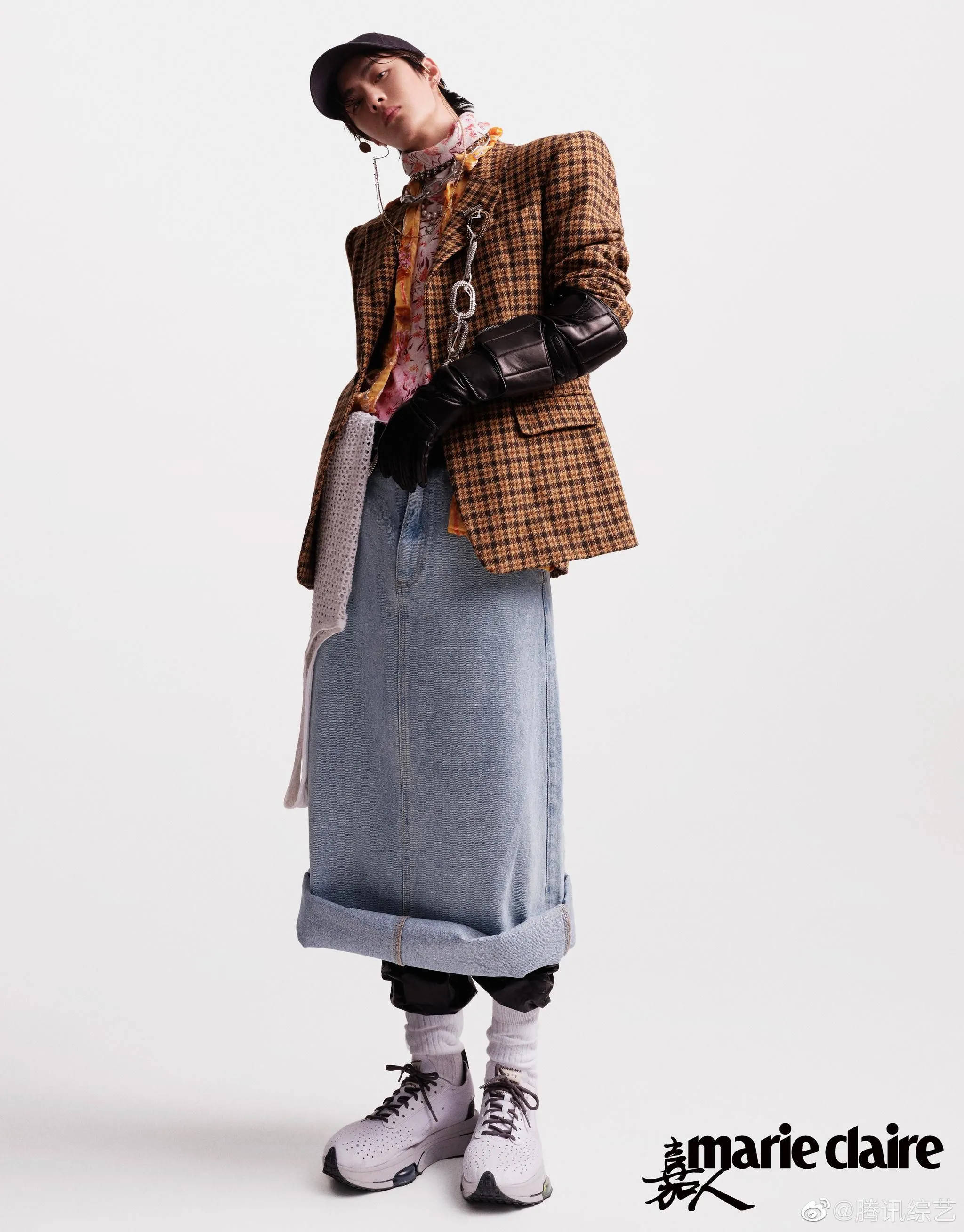 王一博《Marie Claire》六月封面 壁紙 — 一位時尚人士穿著多層次服裝，包括格紋西裝外套、牛仔裙和運動鞋，在純白背景前擺姿勢。