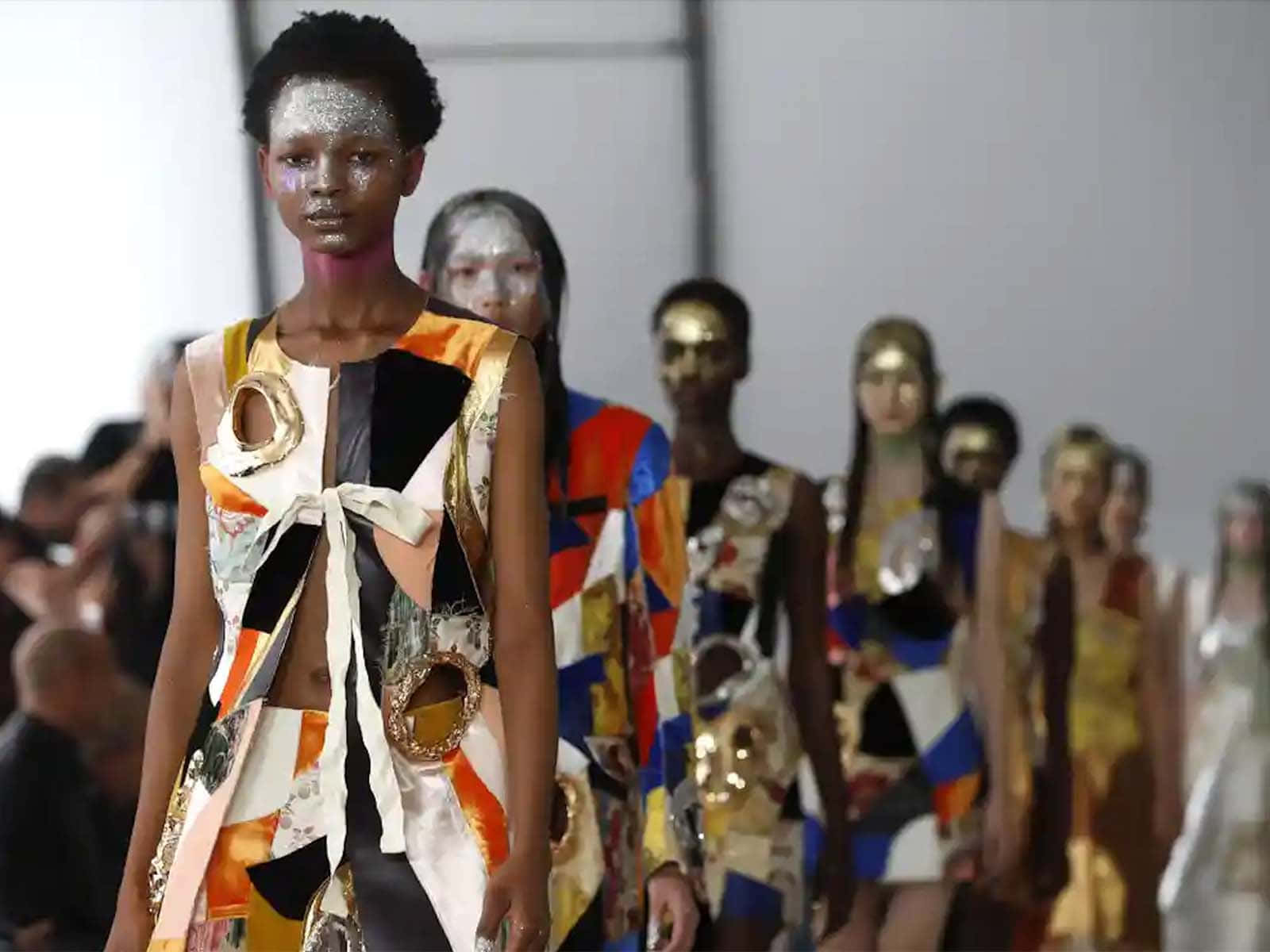 Marni 2021秋冬時裝秀 壁紙 — 模特兒在明亮燈光下，穿著前衛拼布服裝和金屬臉部彩繪走秀。