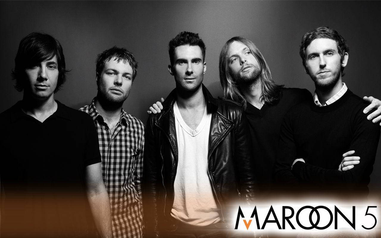 Maroon 5 黑白桌面壁紙 壁紙 — 五位男士在帶有溫暖漸變燈光的黑白工作室肖像中，底部有樂隊名稱 Maroon 5。