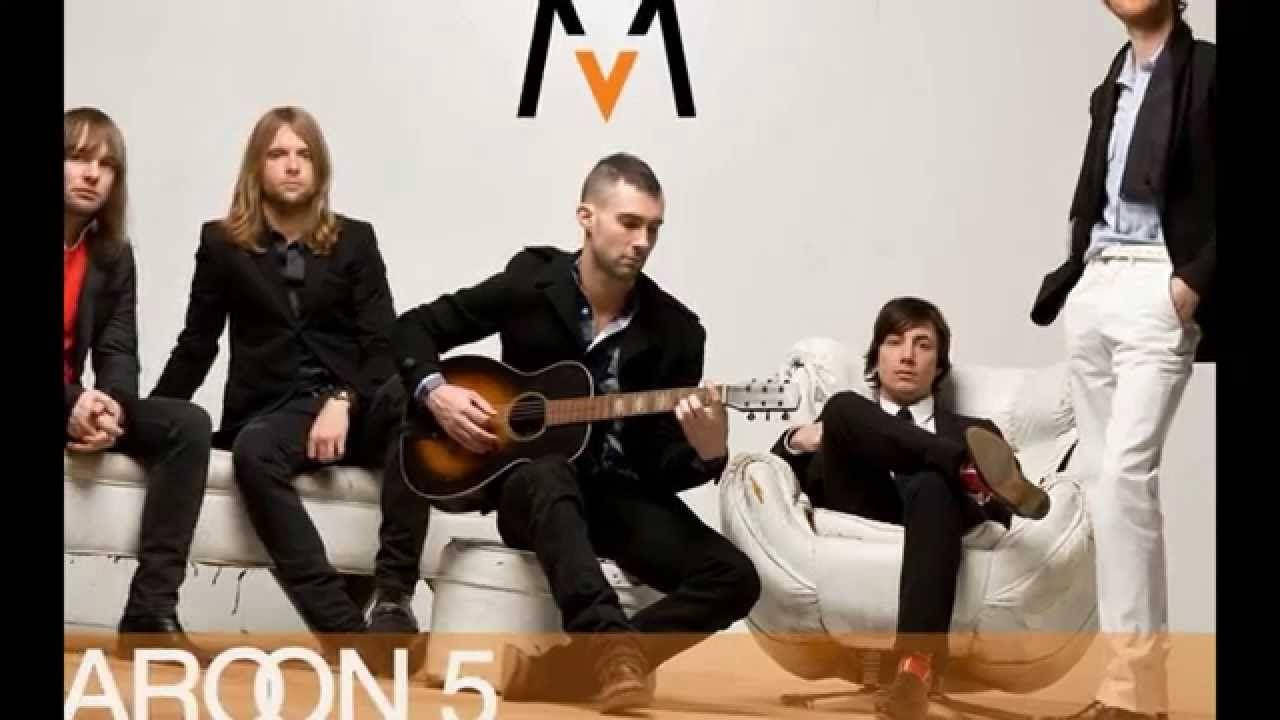 Maroon 5 宣傳縮圖 壁紙 — 五個穿黑色西裝的男人在白色家具上隨意擺姿勢，其中一個在極簡白色牆前彈奏木結他。