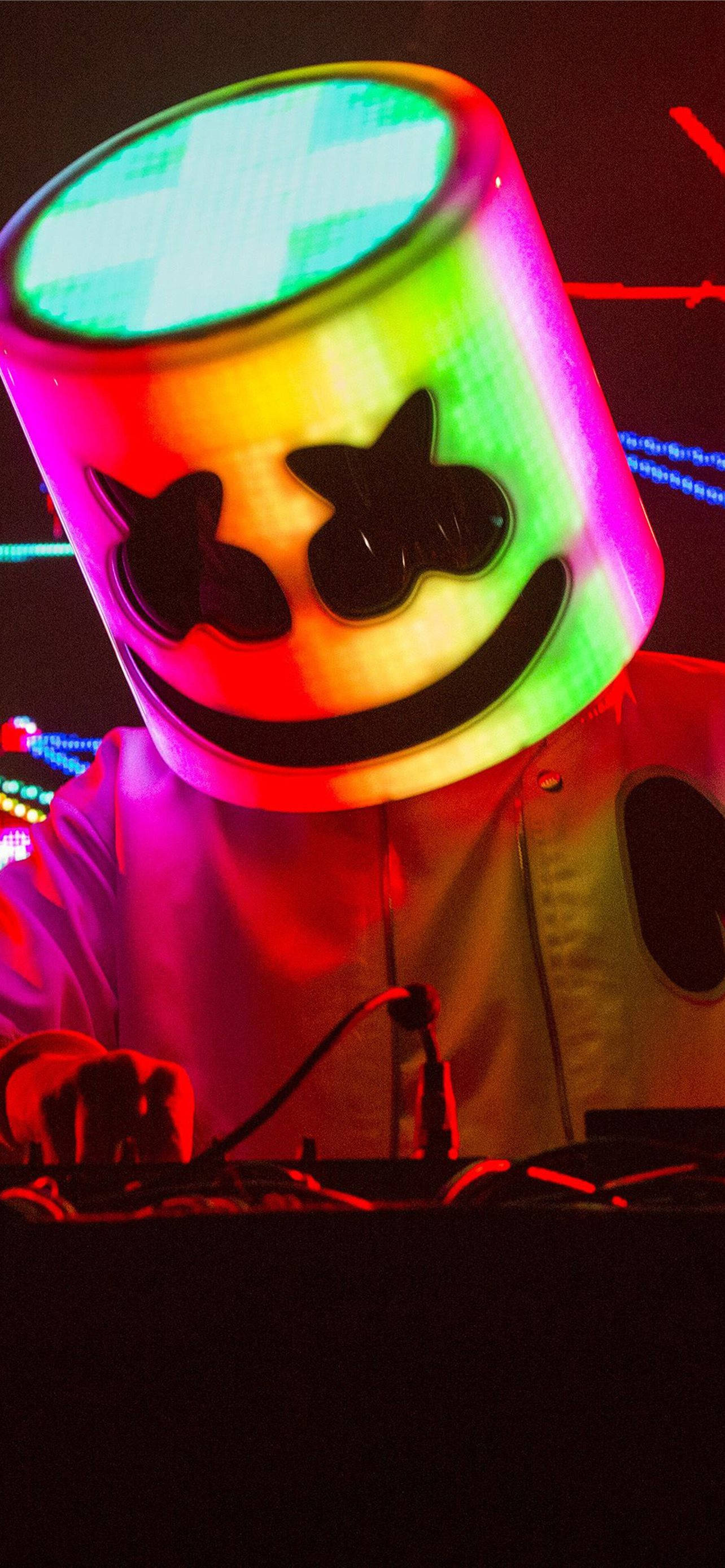 彩虹燈光頭盔 Marshmello iPhone 高畫質壁紙 壁紙 — 一位DJ戴著發光的彩虹棉花糖頭盔，露出燦爛的笑容和星星眼，在充滿活力的音樂會上。