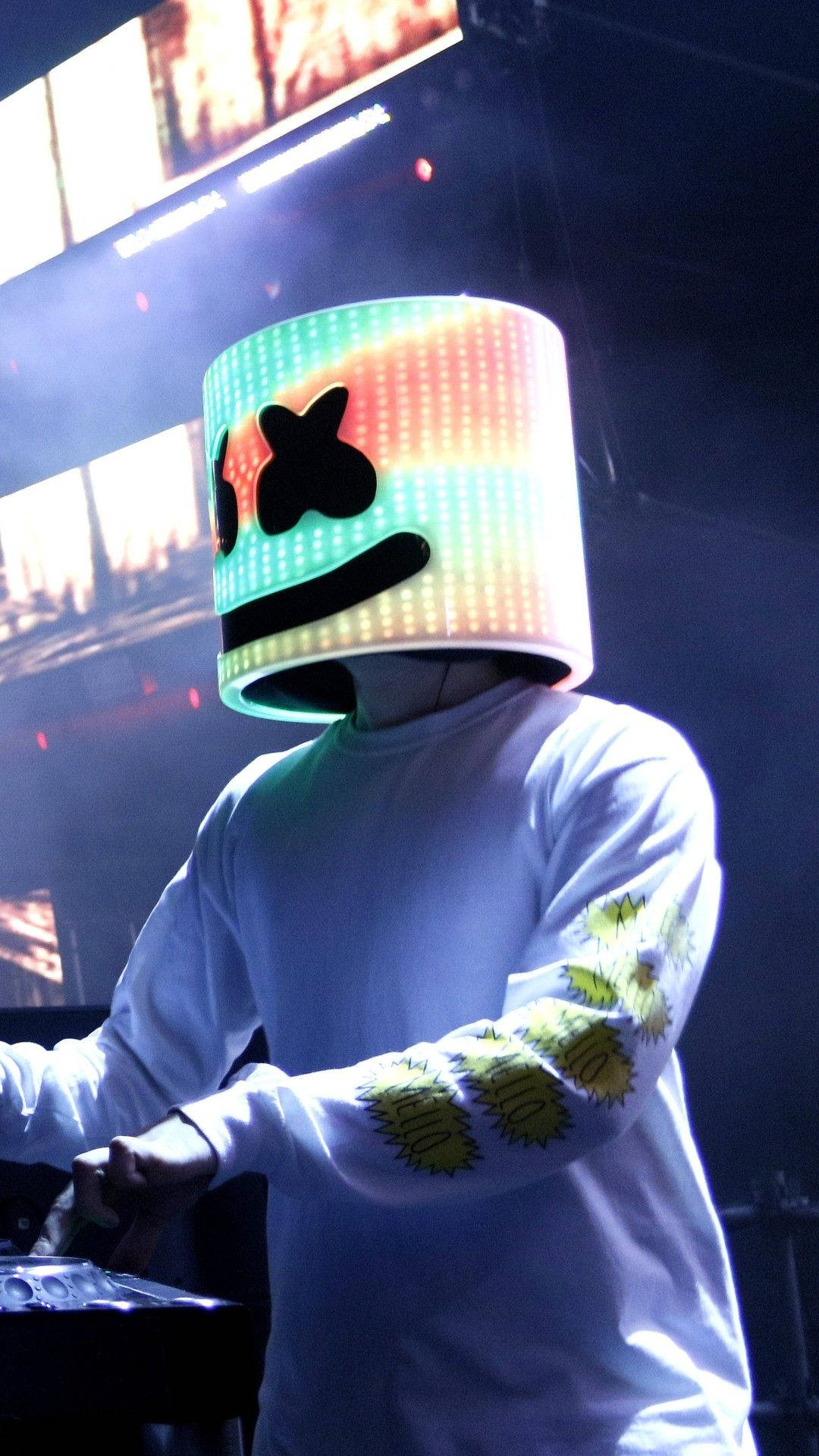 Marshmello 演唱會場景 粉彩頭盔 iPhone 高畫質壁紙 壁紙 — DJ Marshmello 戴著標誌性的發光頭盔，在音樂會的舞台燈光下表演。