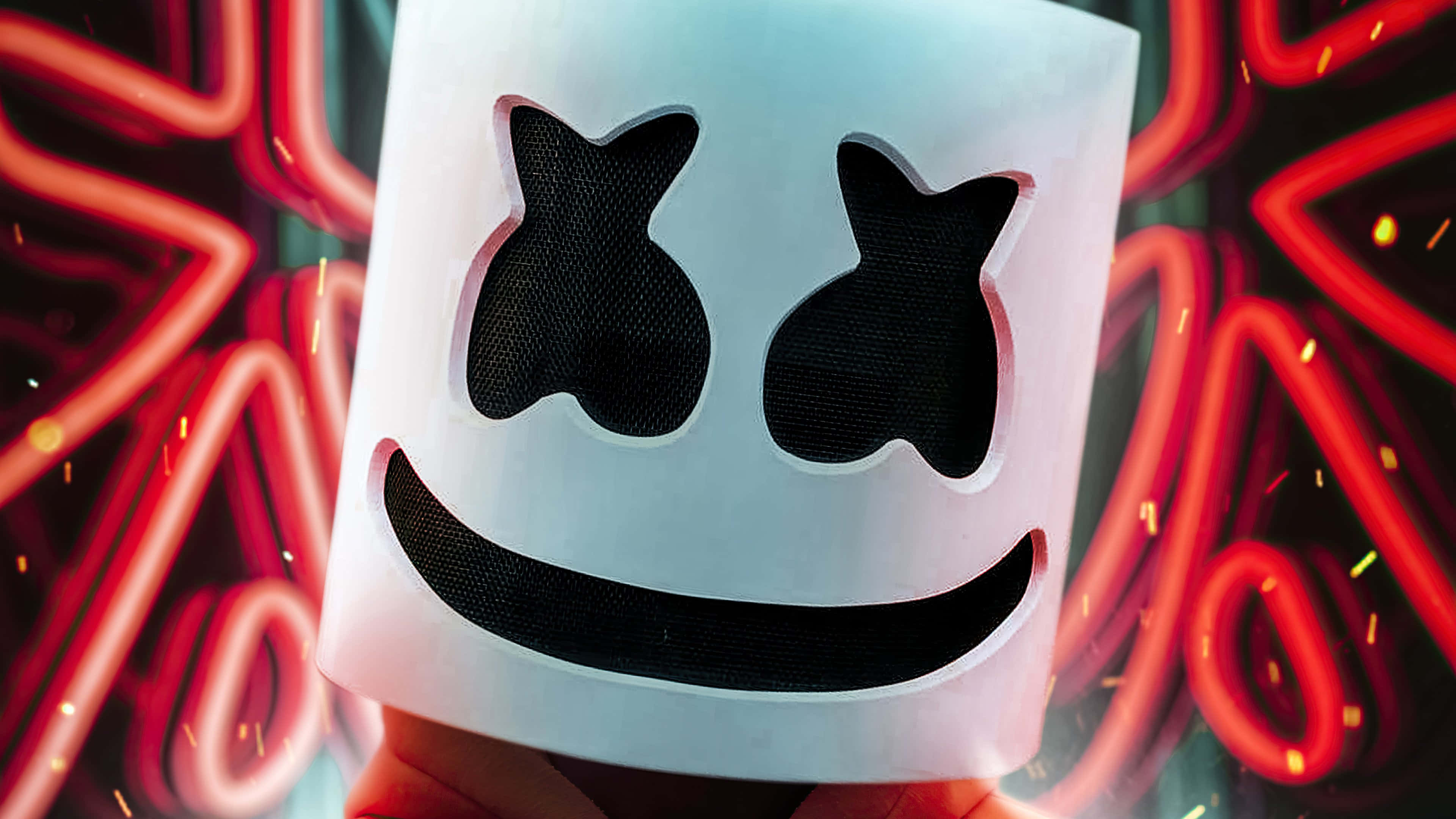 Marshmello 桌布 壁紙 — Marshmello 標誌性白色頭盔的特寫，帶有黑色網眼眼睛和微笑，背景是充滿活力的紅色霓虹燈和火花。