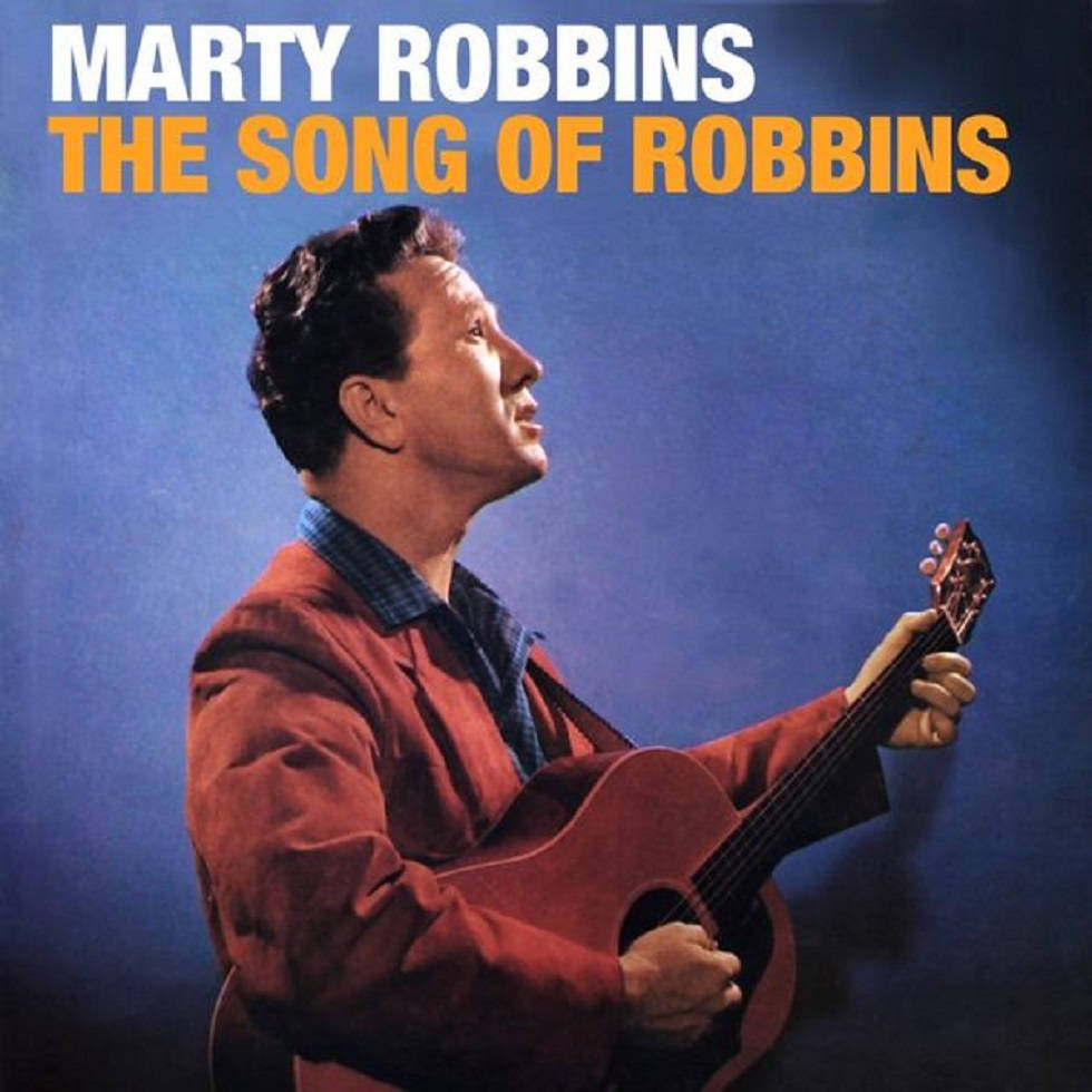 羅賓斯的歌聲 Marty Robbins 壁紙 — Marty Robbins 抬頭仰望，手持木結他，背景為深藍色攝影棚，並有粗體專輯標題文字。