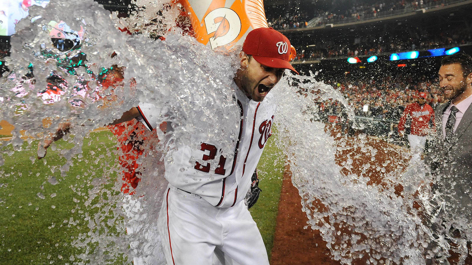 Max Scherzer 比賽慶祝 壁紙 — 一名身穿白色31號球衣的棒球手在夜間球場上慶祝時被水淋得濕透。