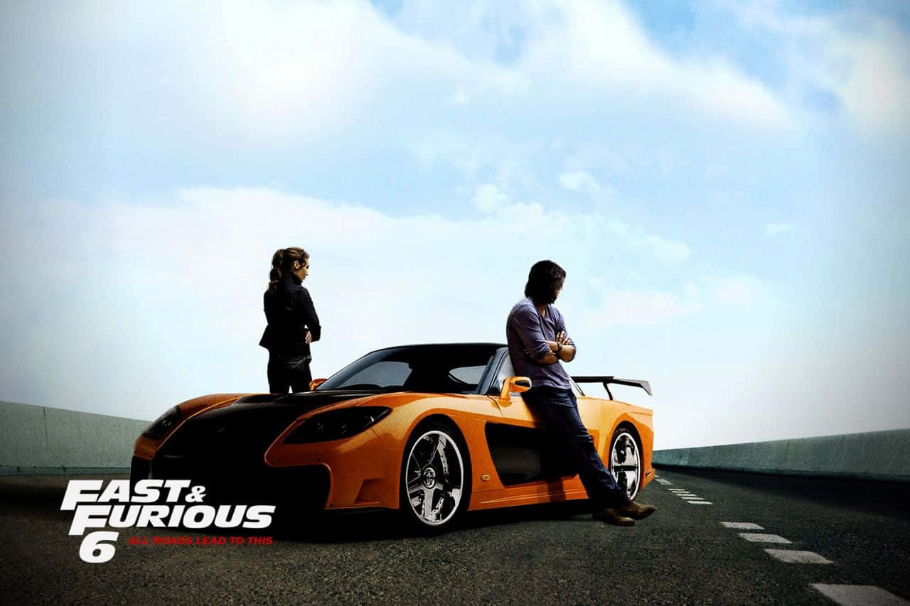 Mazda RX-7 FD 最佳《速度與激情》背景 壁紙 — 兩個人自信地站在一輛充滿活力的橙色跑車旁邊，在開闊的高速公路上，天空明亮。
