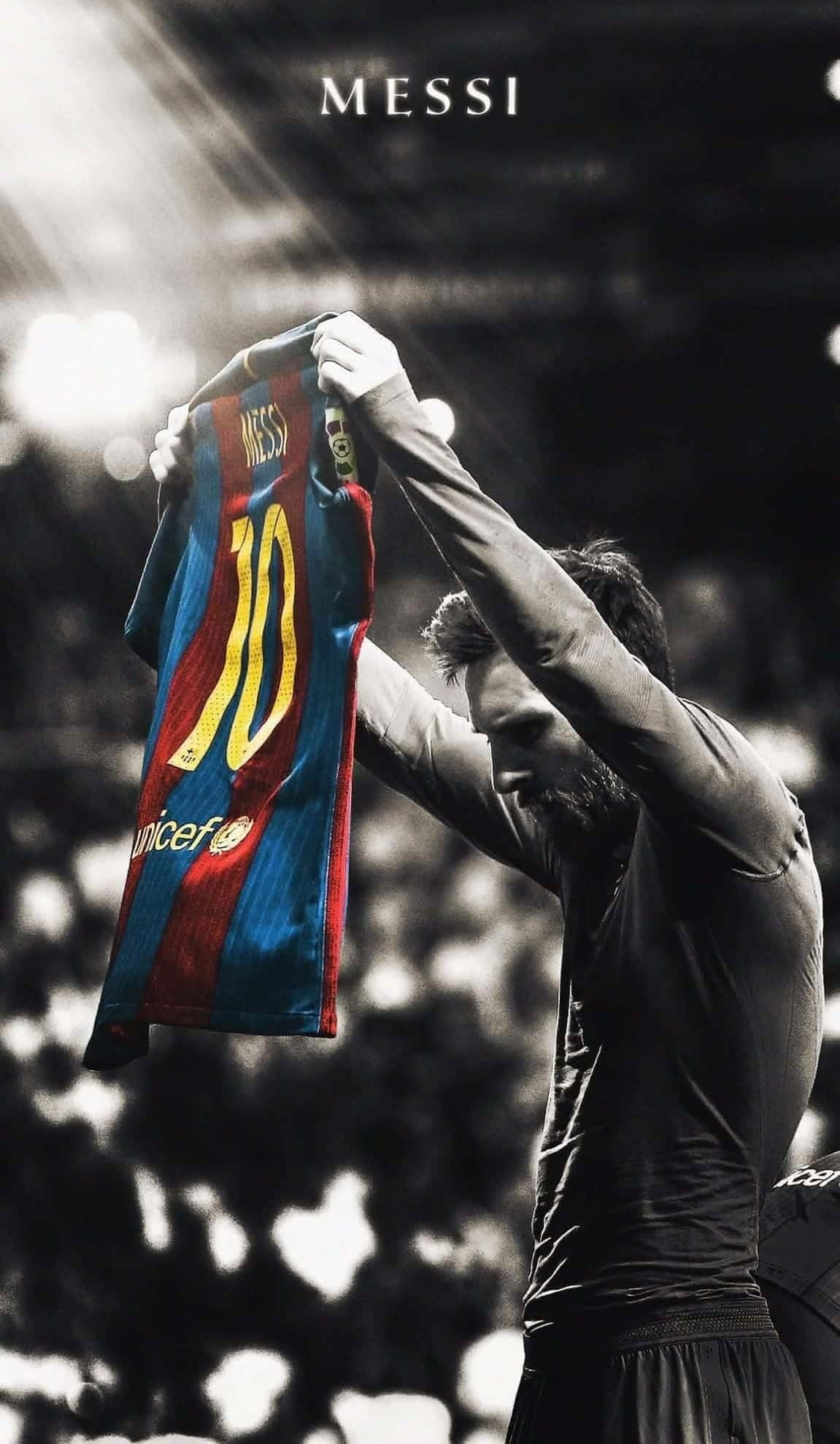 Messi 2022 桌布 壁紙 — 美斯在球場燈光下，以戲劇性的聚光燈效果高舉他標誌性的巴塞隆拿10號球衣。