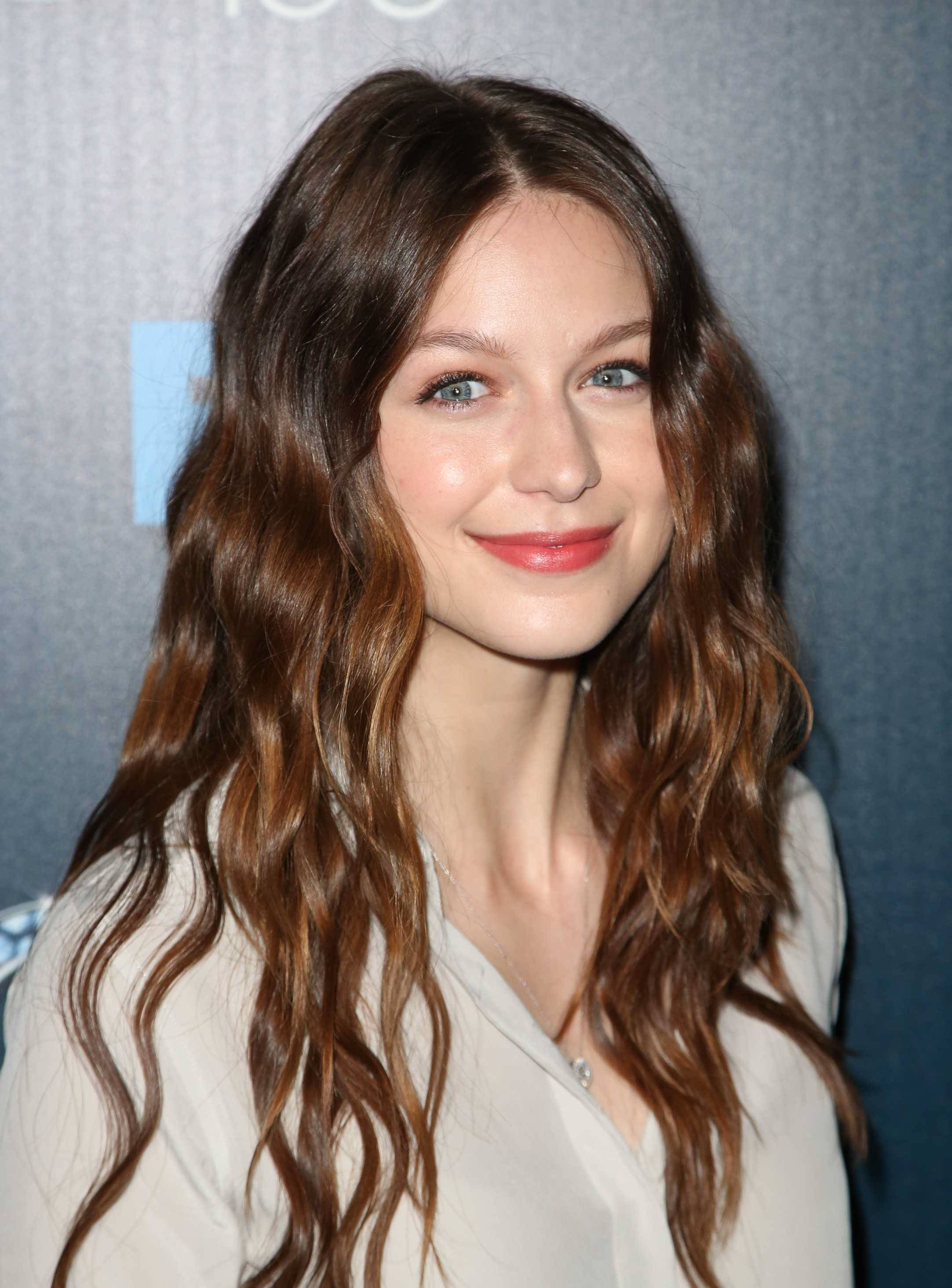 Melissa Benoist 潮流捲髮 壁紙 — 一位擁有長波浪棕色頭髮和明亮藍眼睛的女性近距離肖像，溫柔地對著鏡頭微笑。