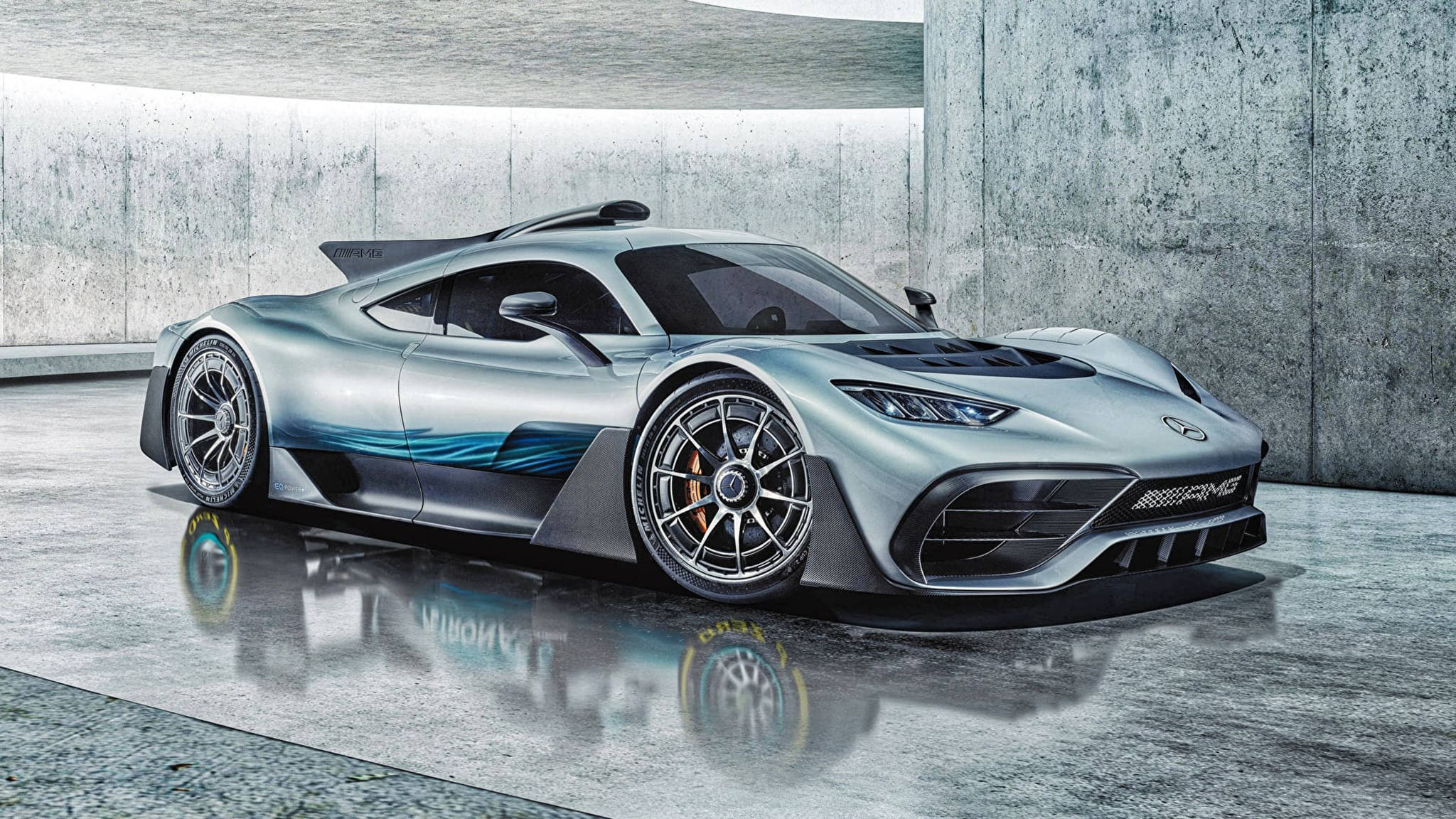 酷炫Mercedes AMG Project One 壁紙 — 一輛帶有藍色點綴的時尚銀色 Mercedes-AMG One 超跑停在簡約工業車庫的潮濕混凝土地板上。