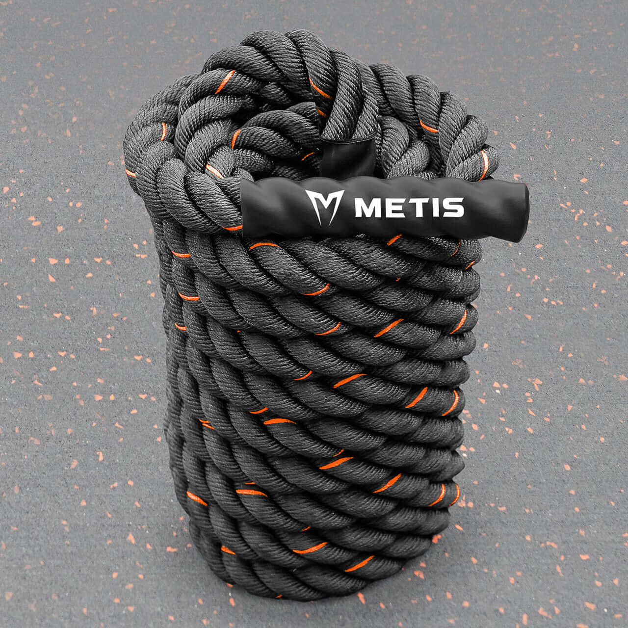 Metis 戰鬥繩圈畫作 壁紙 — 一條粗大的黑色戰鬥繩，帶有橙色點綴和黑色品牌手柄，放置在斑點灰色健身房地板上。