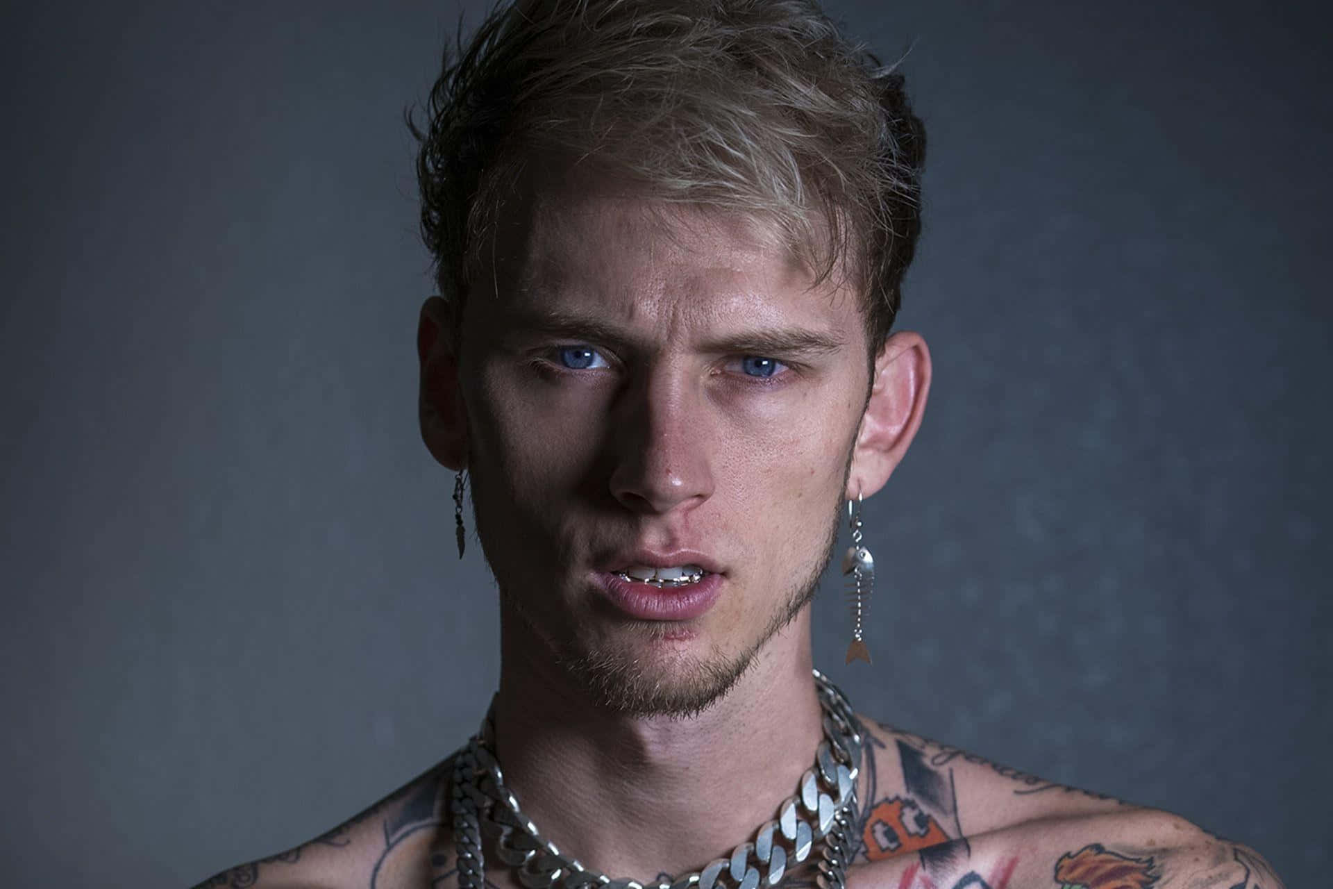 有紋身和鏈條項鍊的年輕男子強烈凝視。