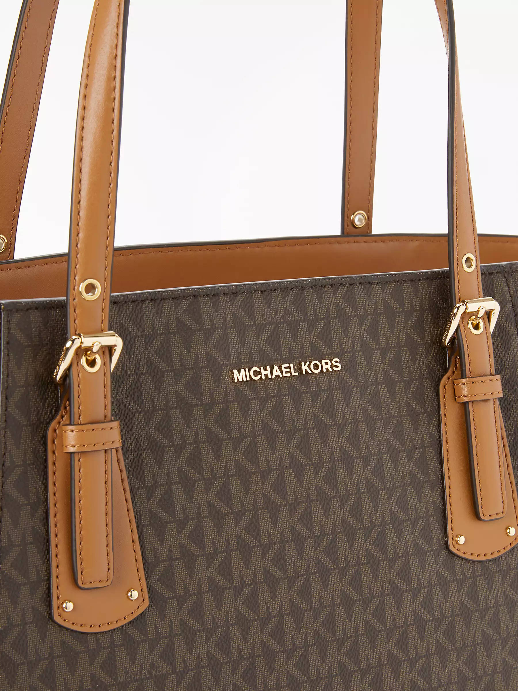 Michael Kors 經典手袋設計 壁紙 — 白色背景上，棕色Michael Kors托特包、棕褐色皮革肩帶和金色金屬配件的特寫。