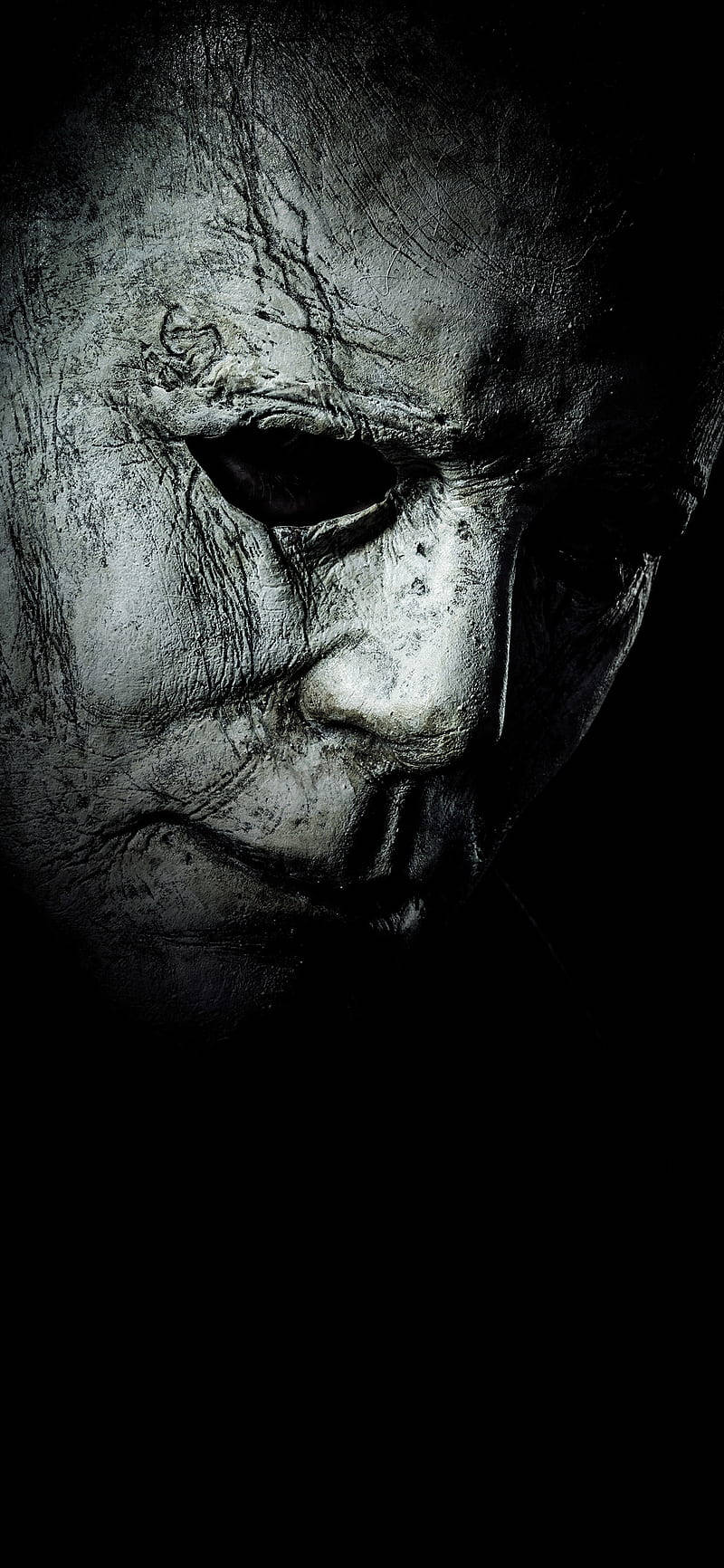 horror villains 桌布 壁紙 — Michael Myers 傷痕累累的蒼白臉部在陰影黑暗中帶有強烈眼窩的令人毛骨悚然的特寫。