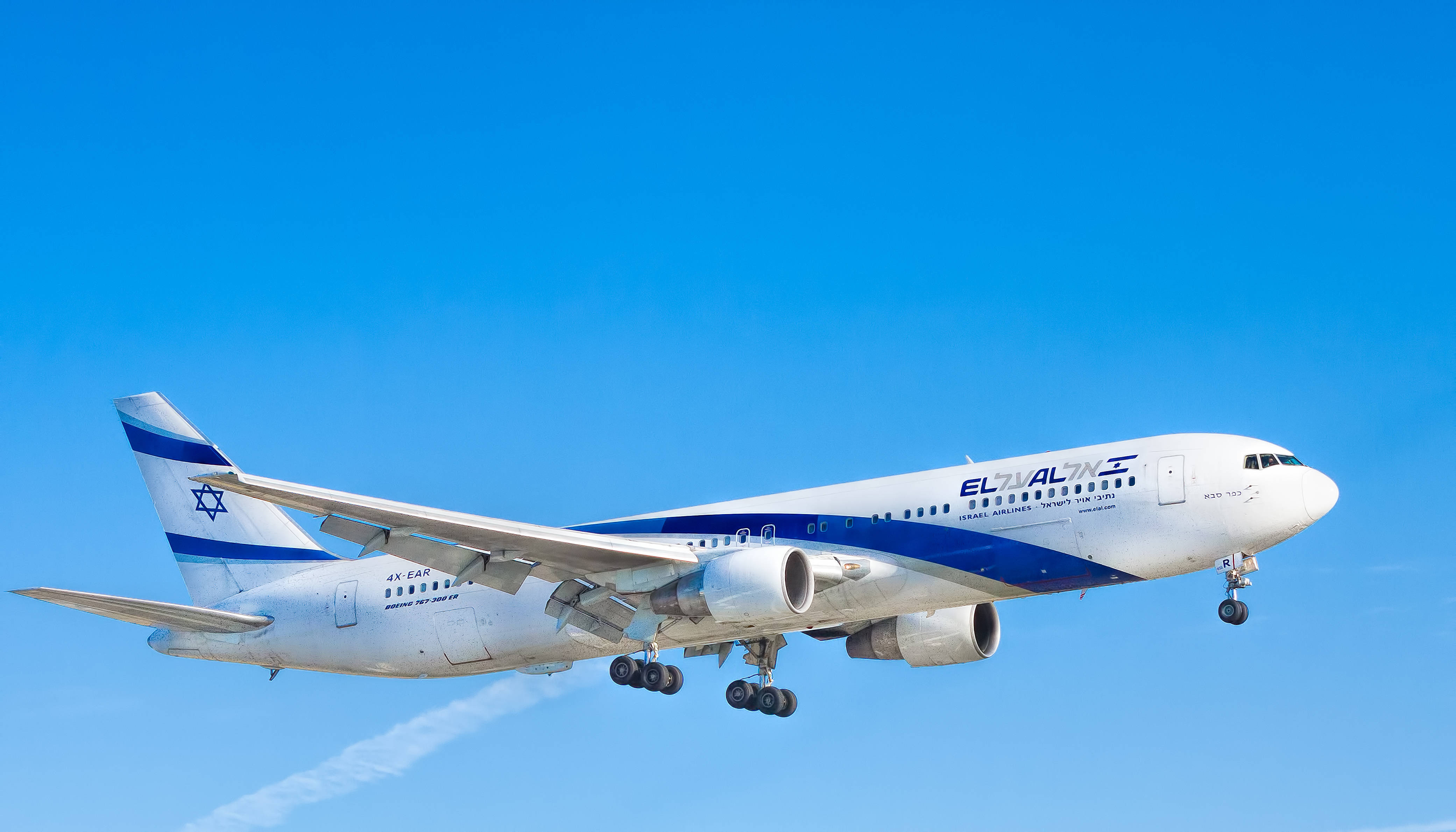 Microsoft Flight Simulator 以色列航空飛機 壁紙 — 一架白色和藍色塗裝的以色列航空空中巴士A340，在晴朗的藍天下放下起落架下降。