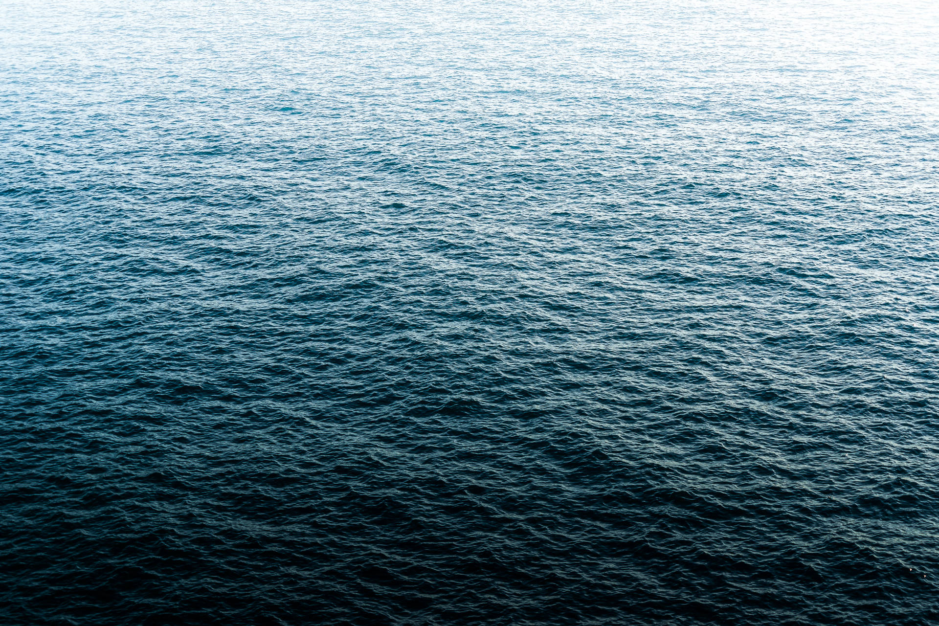 平靜嘅海洋，喺日光下有深藍色波浪