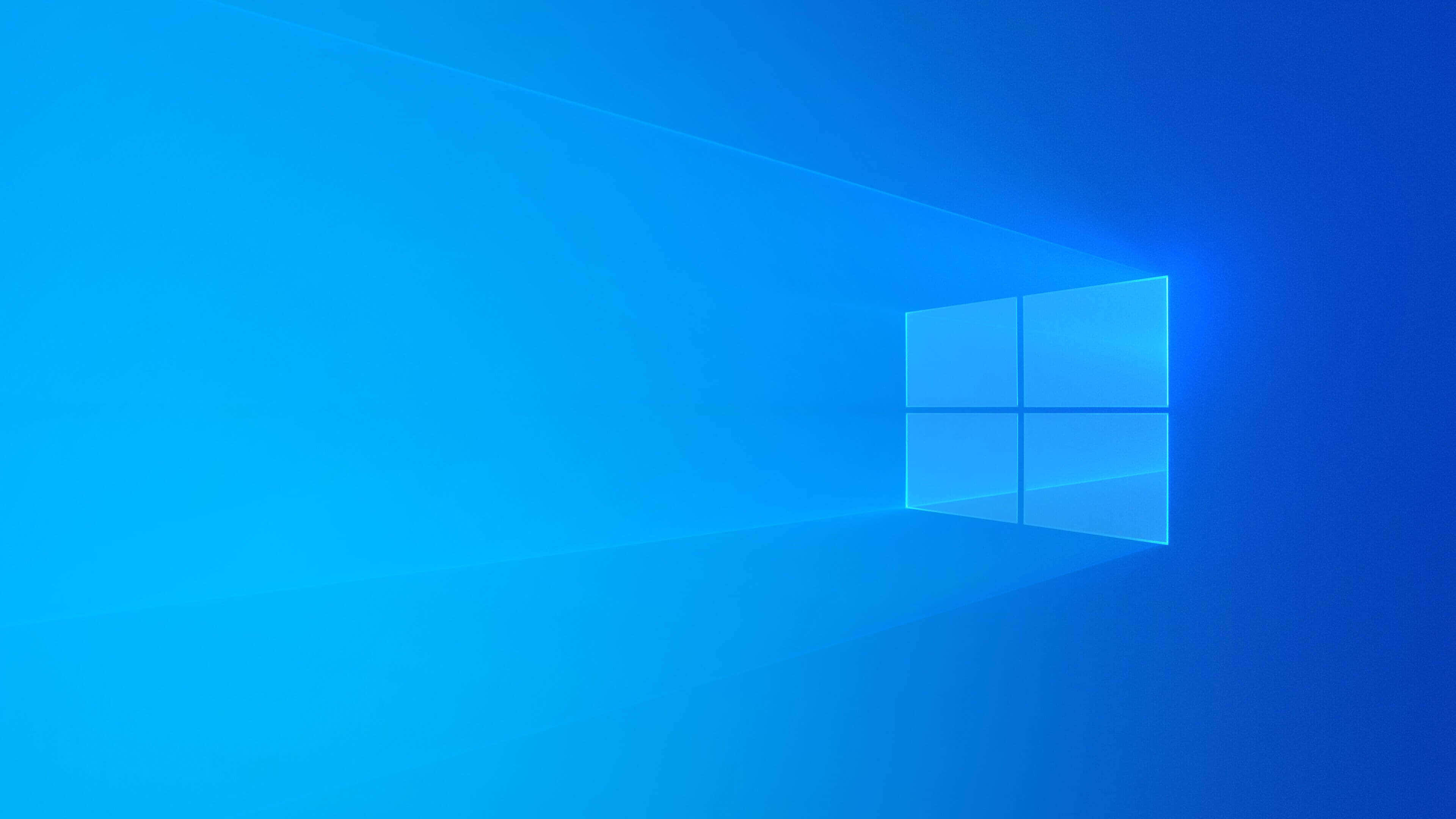 Microsoft Windows 預設桌面背景 壁紙 — 一個發光的藍色窗戶標誌漂浮在漸變藍色虛空中，背後散發出柔和的光線。