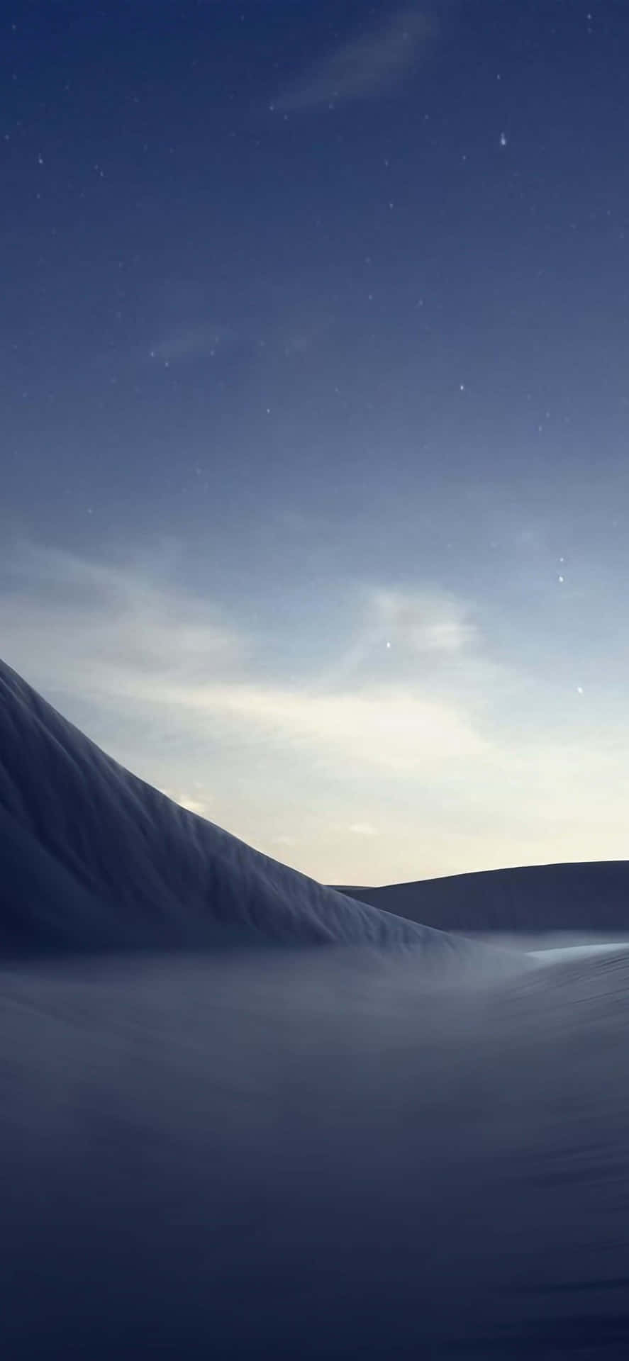 在帶有蒼白暮色光芒的星空下的雪山。