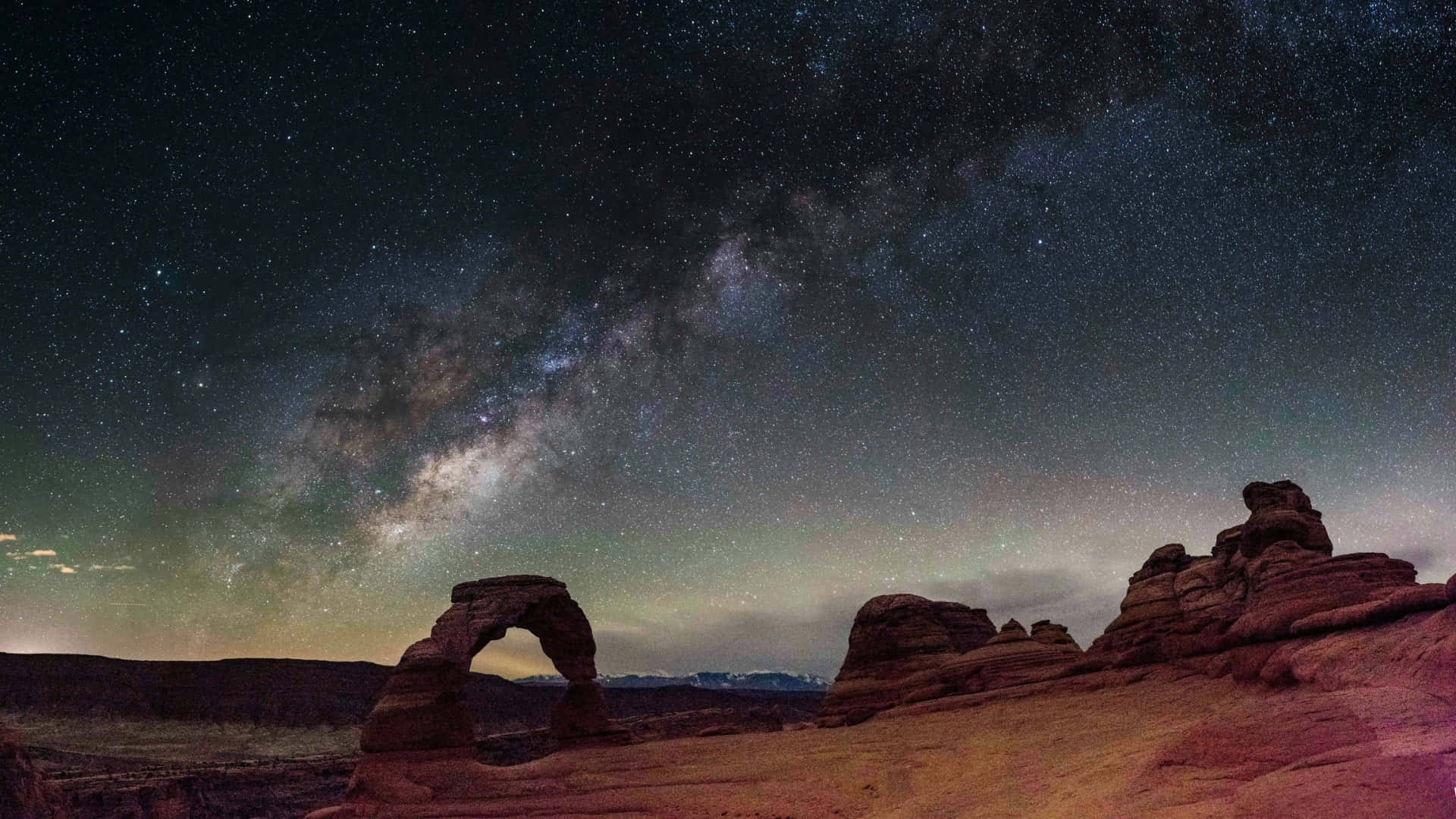  壁紙 — 銀河系在星空下拱越沙漠岩石地貌。