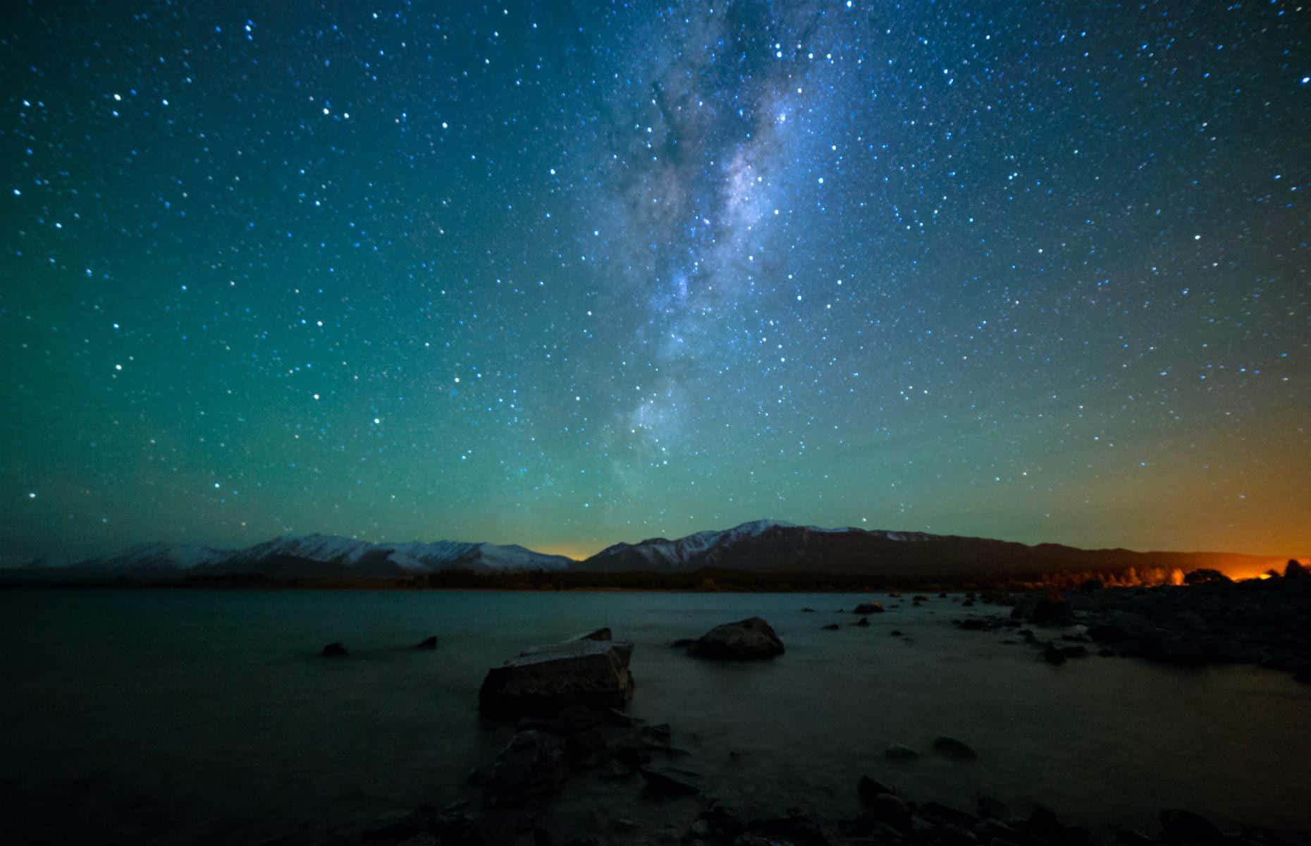  壁紙 — 銀河系在積雪的山峰上空彎曲，倒映在平靜的湖面上，星空燦爛的夜空。