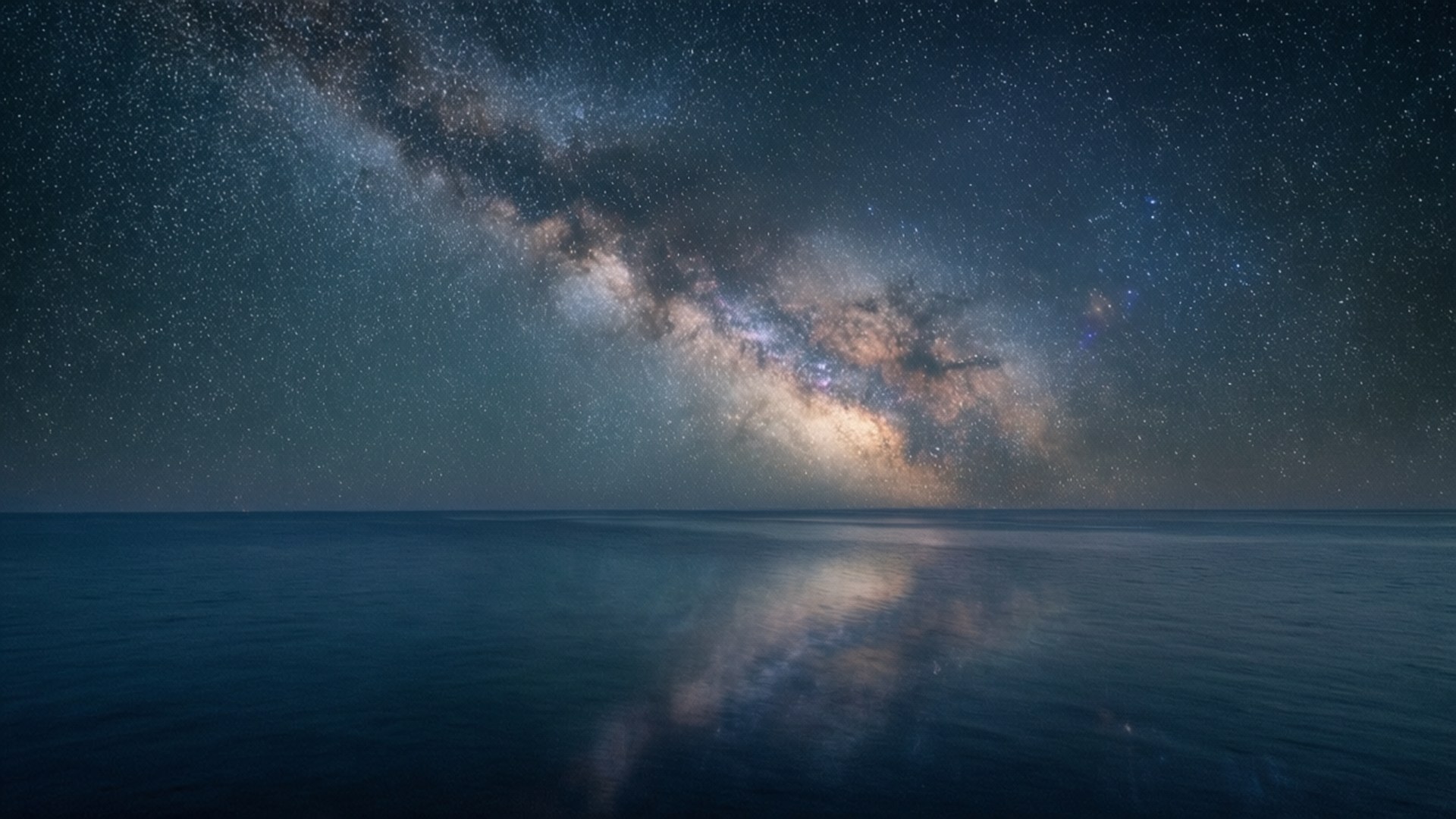 銀河系倒映在平靜的海面上，星空夜空下