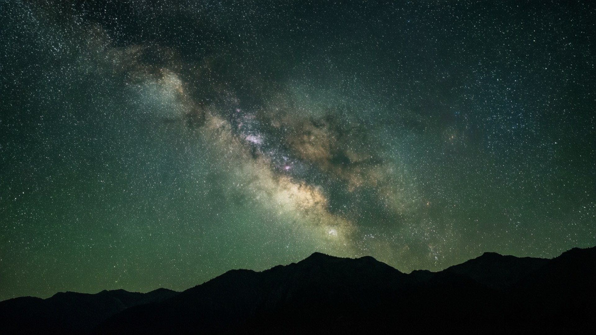 銀河系在星光照耀的夜空下在黑暗山脈上方發光