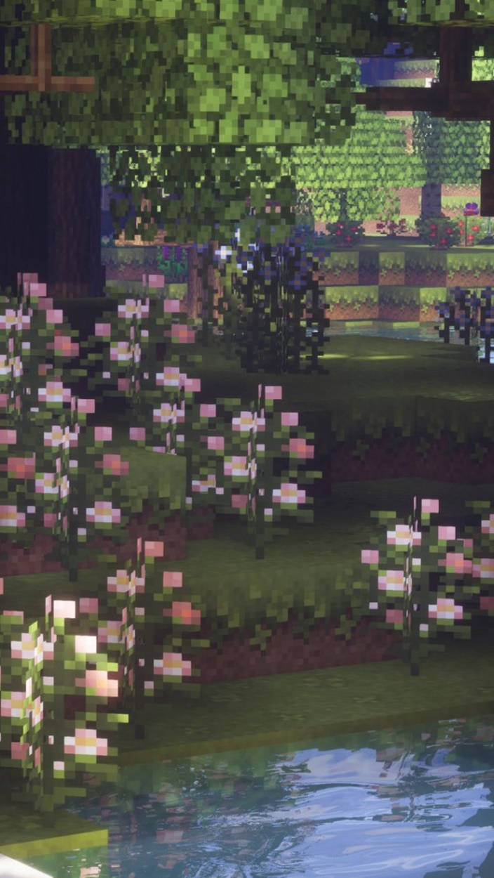 遊戲生物花 Minecraft iPhone 壁紙 — 像素風格花園，有粉紅色花朵和綠色樹木，旁邊是平靜的水面，Minecraft風格。