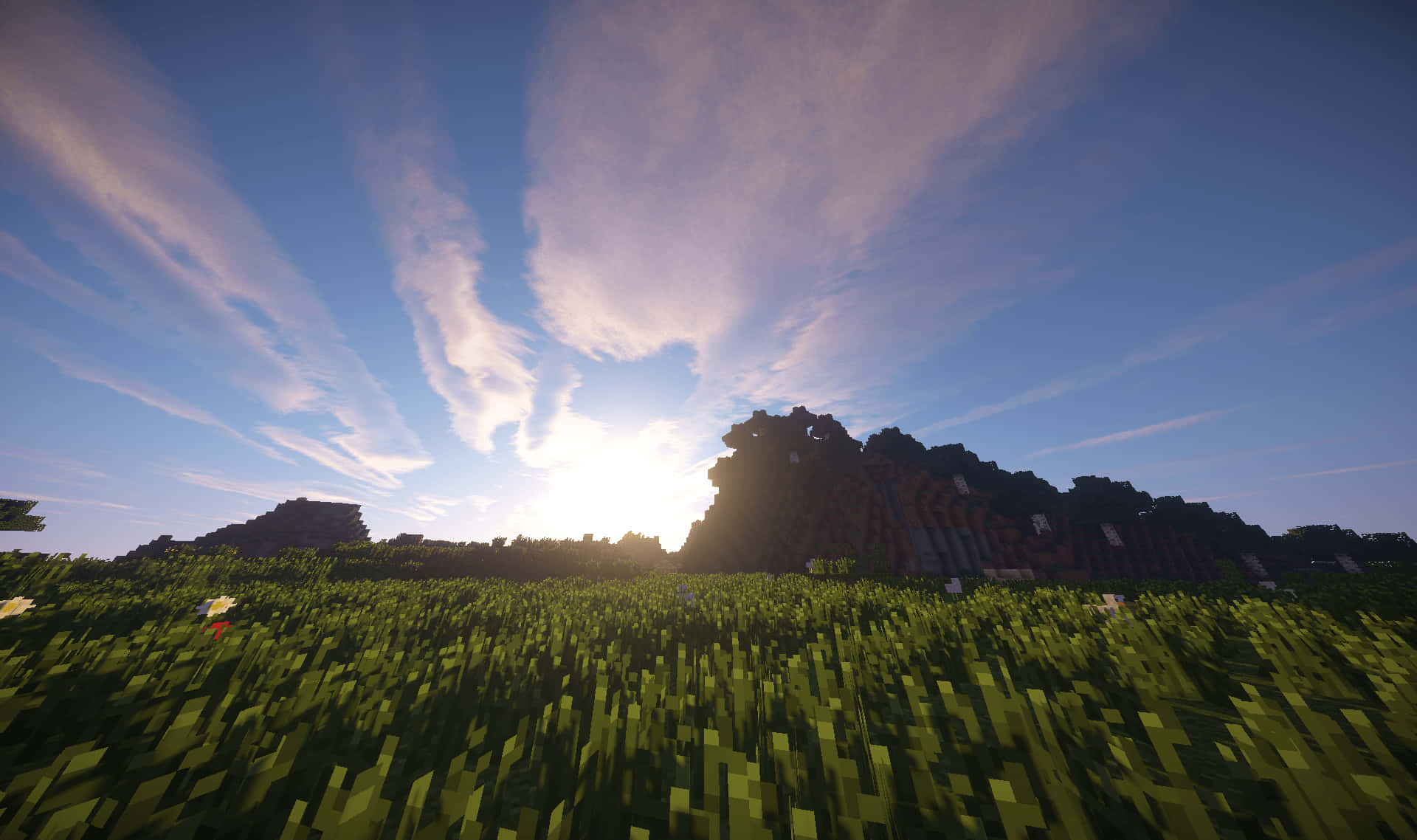 享受令人驚嘆的視覺效果，體驗 Minecraft Shader 壁紙 — 日落時分，在紫色和藍色雲彩交織的天空下，崎嶇的山脈矗立在塊狀的草原平原上。