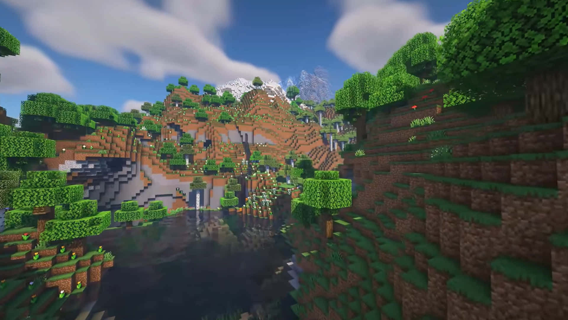 一個Minecraft場景，瀑布流入被綠色樹木和山丘環繞的湖泊，天空湛藍。